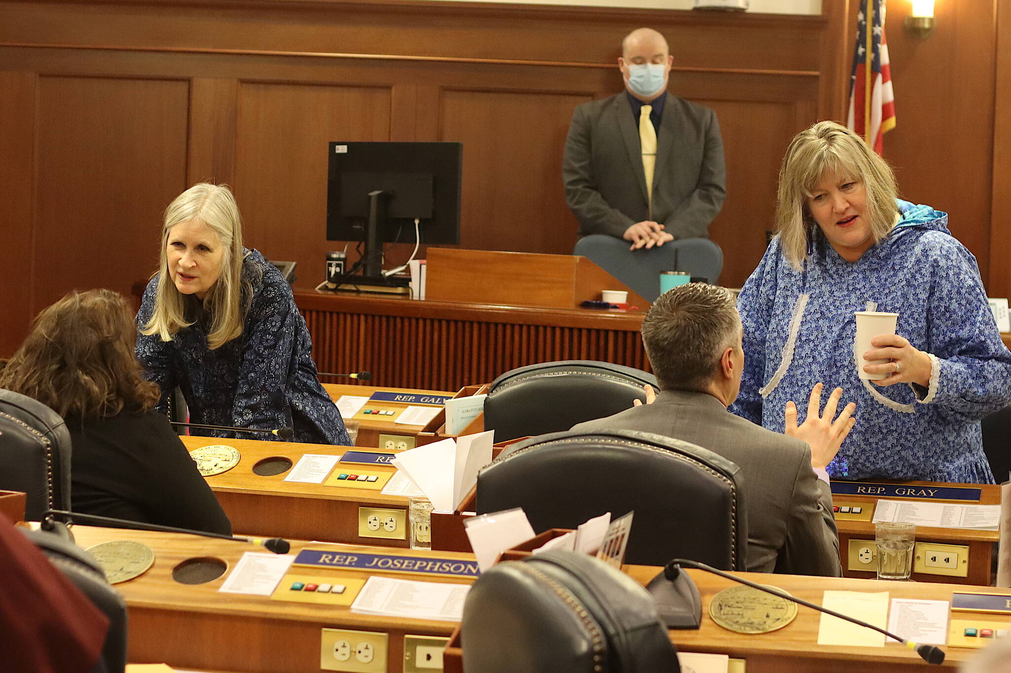 Juneau state Reps. Andi Story, left, and Sara Hannan wear kuspuks while talking with fellow House members just before U.S. Rep. Mary Peltola’s first speech as a congresswoman to a joint session of the Alaska State Legislature on Friday. (Mark Sabbatini / Juneau Empire)