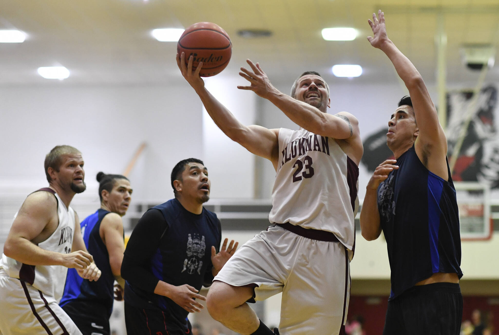 Klukwan’s Michael Ganey, center, shoots against Hydaburg’s Ben Young in the C final at the 2019 Gold Medal Basketball Tournament. The tournament returns this March after a three-year hiatus due to the pandemic. (Michael Penn / Juneau Empire File)