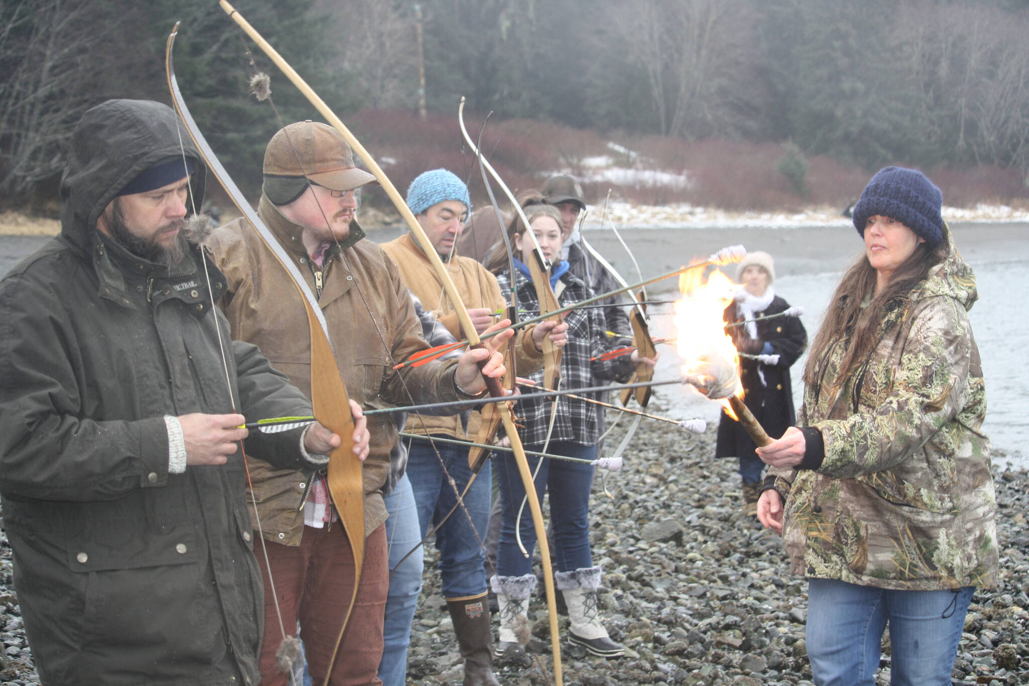 Jenna Cameron lights a row of arrows to pay tribute to her uncle Daniel Sargent during his memorial on Saturday at Raven Shelter. (Jonson Kuhn / Juneau Empire)