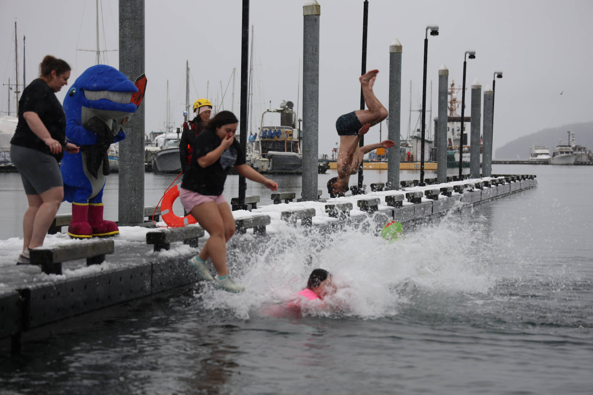 A group of University of Alaska Southeast students jump into the waters of Auke Bay on Saturday afternoon for the 25th UAS Polar Plunge. (Clarise Larson / Juneau Empire)