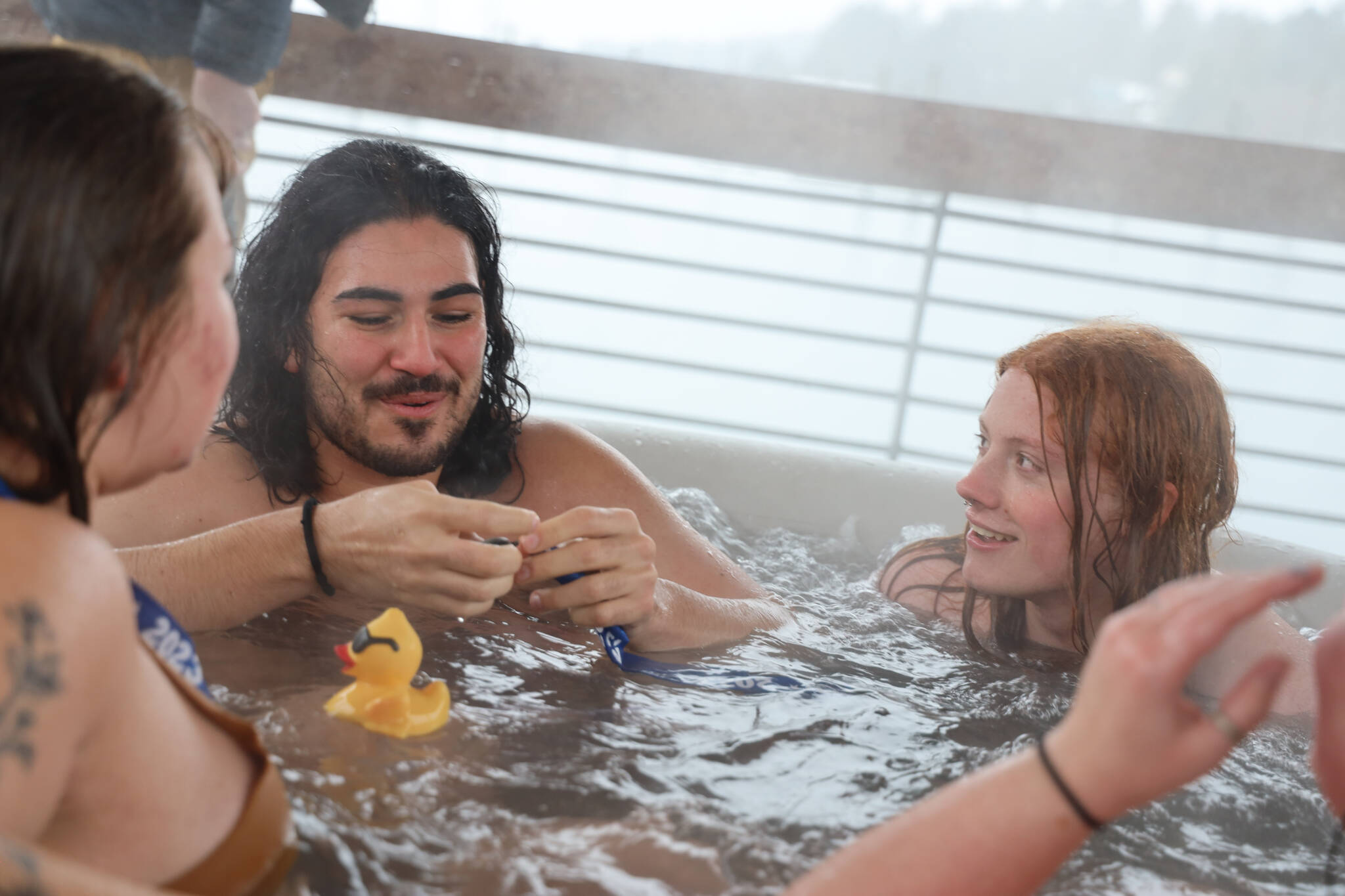 University of Alaska Southeast students relax in a hot tub after jumping into the waters of Auke Bay on Saturday afternoon for the 25th UAS Polar Plunge. (Clarise Larson / Juneau Empire)