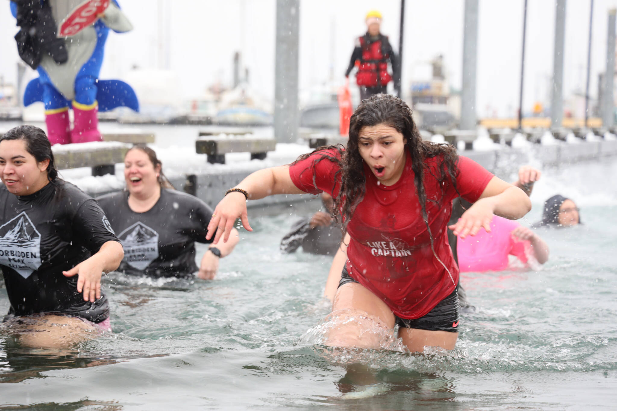 University of Alaska Southeast students run out of the freezing water after jumping into the waters of Auke Bay on Saturday afternoon for the 25th UAS Polar Plunge. (Clarise Larson / Juneau Empire)