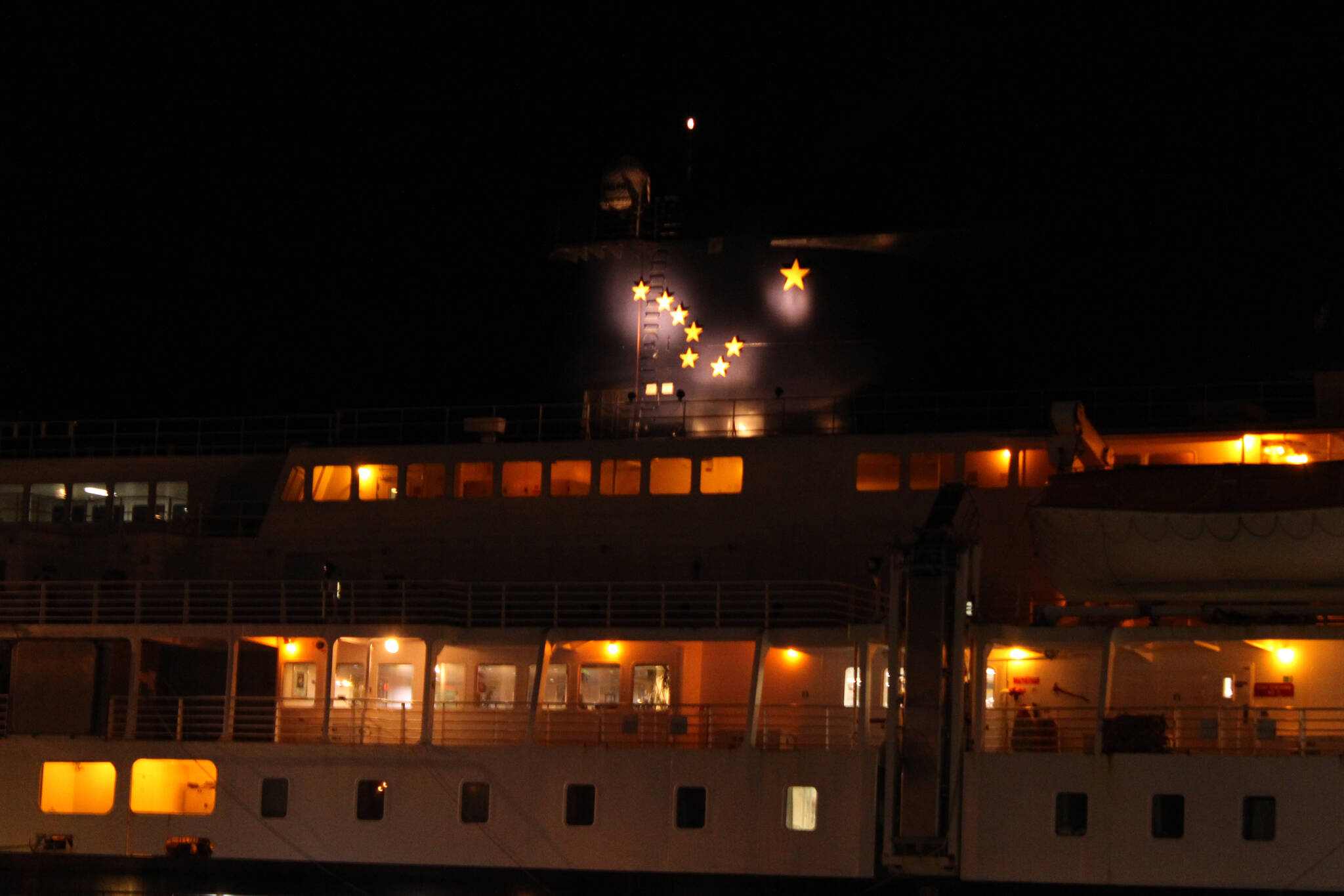 The Alaska state flag is illuminated atop the Kennicott at night at Juneau's Auke Bay Ferry Terminal. (Ben Hohenstatt / Juneau Empire File)