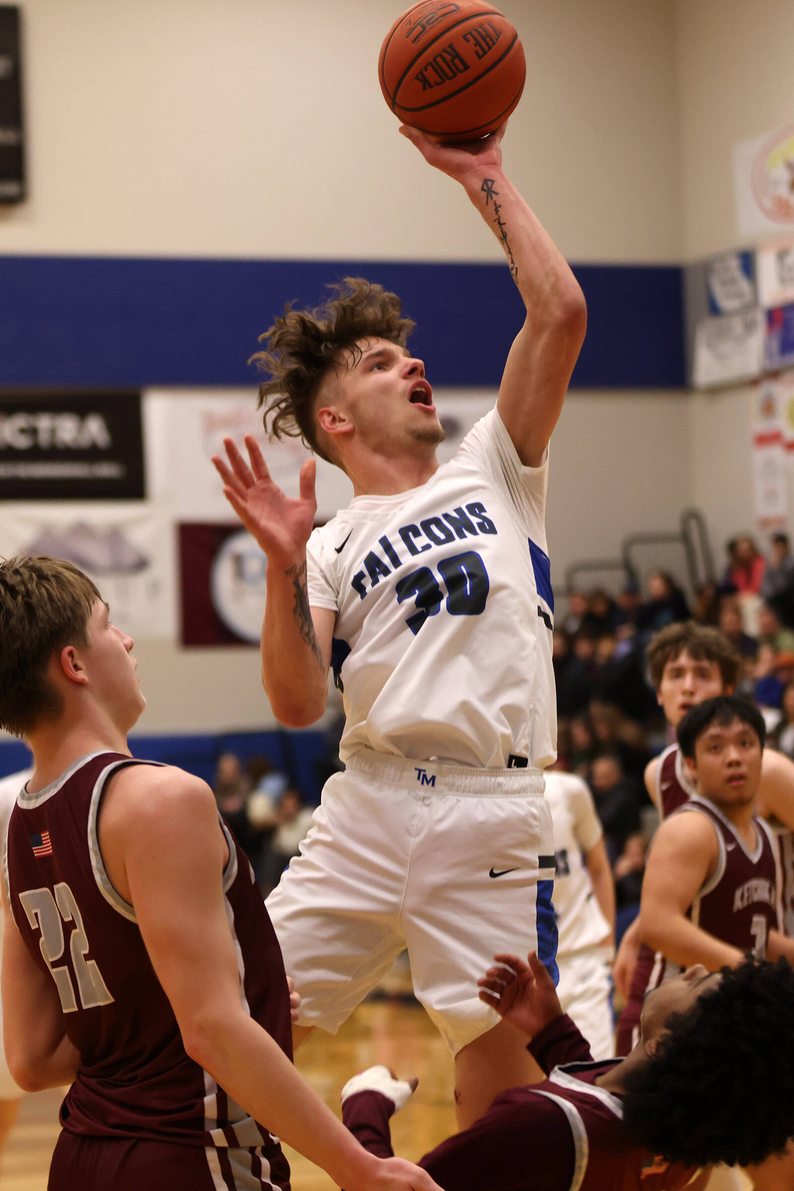 TMHS junior Thomas Baxter (30) takes a tough shot in traffic late in a Friday night 64-59 win against Ketchikan High School. Before the game, Baxter was honored for breaking the 1,000-point mark. He’s the fastest-ever Falcon to do so, and is now third on the school’s all-time scoring list. He finished Friday’s game with 25 points. (Ben Hohenstatt / Juneau Empire)