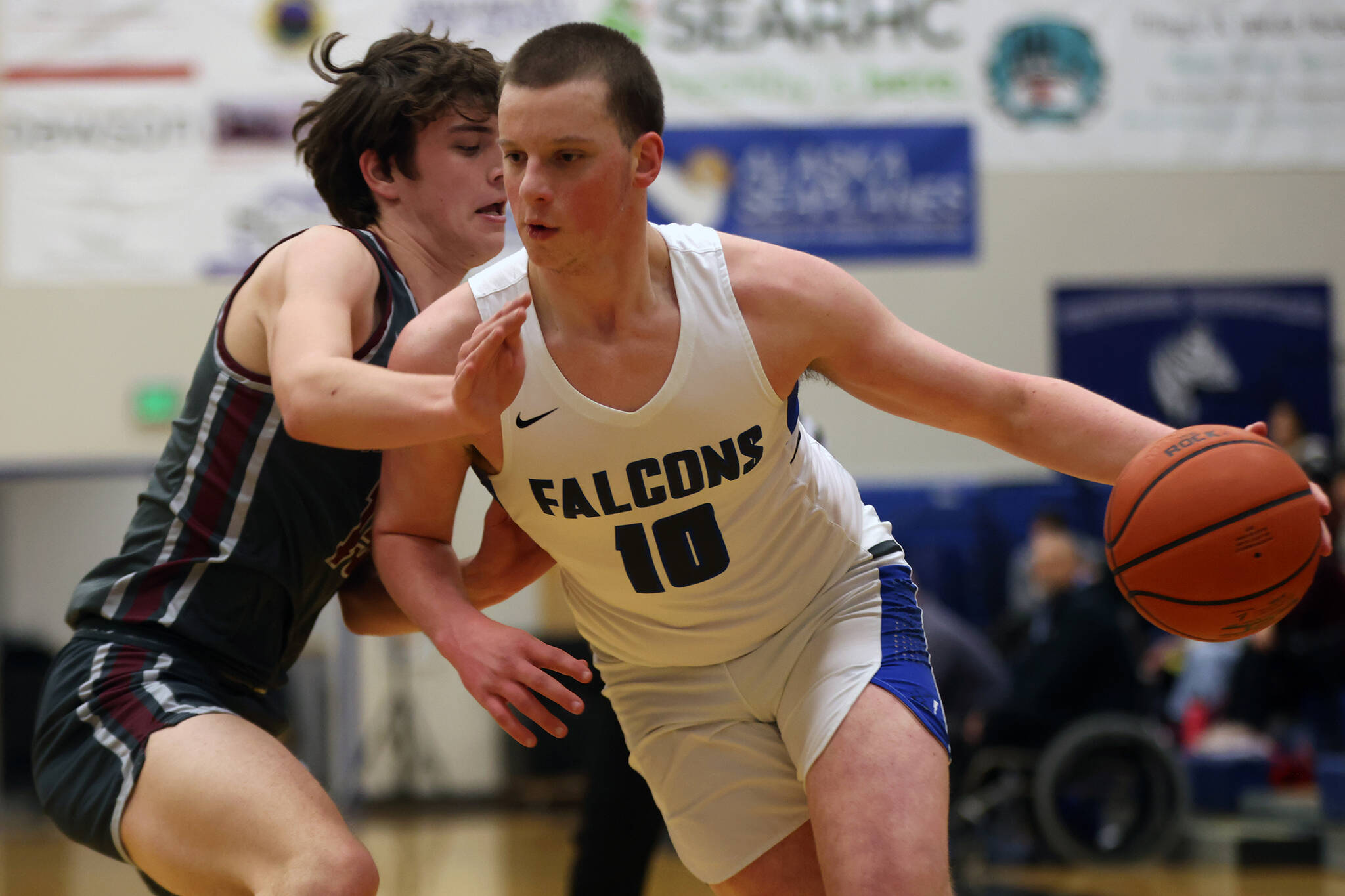 TMHS junior James Polasky (10) closes in on the hoop while Kayhi junior Jared Rhodes (15) works to close off that route. (Ben Hohenstatt / Juneau Empire)