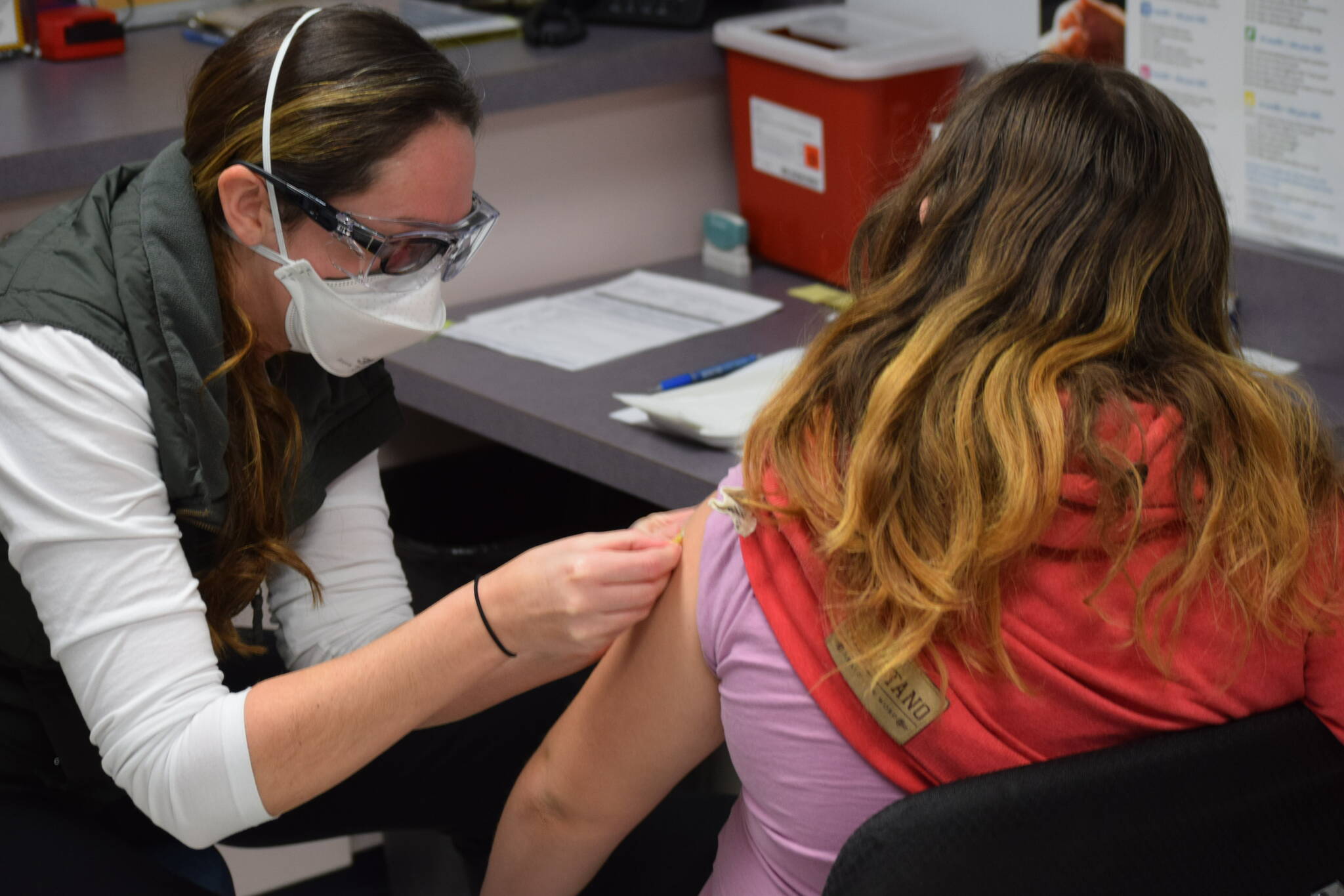 Nurse Sherra Pritchard gives Madyson Knudsen a bandage at the Kenai Public Health Center after the ten-year-old received her first COVID-19 vaccine on Friday, Nov. 5, 2021. (Camille Botello/Peninsula Clarion)