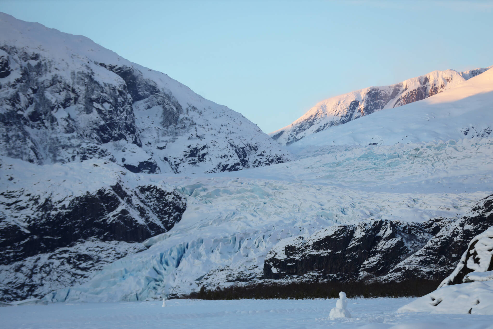 A snowman sits on Mendenhall Lake as the sun sets over the glacier Monday evening. (Clarise Larson / Juneau Empire)