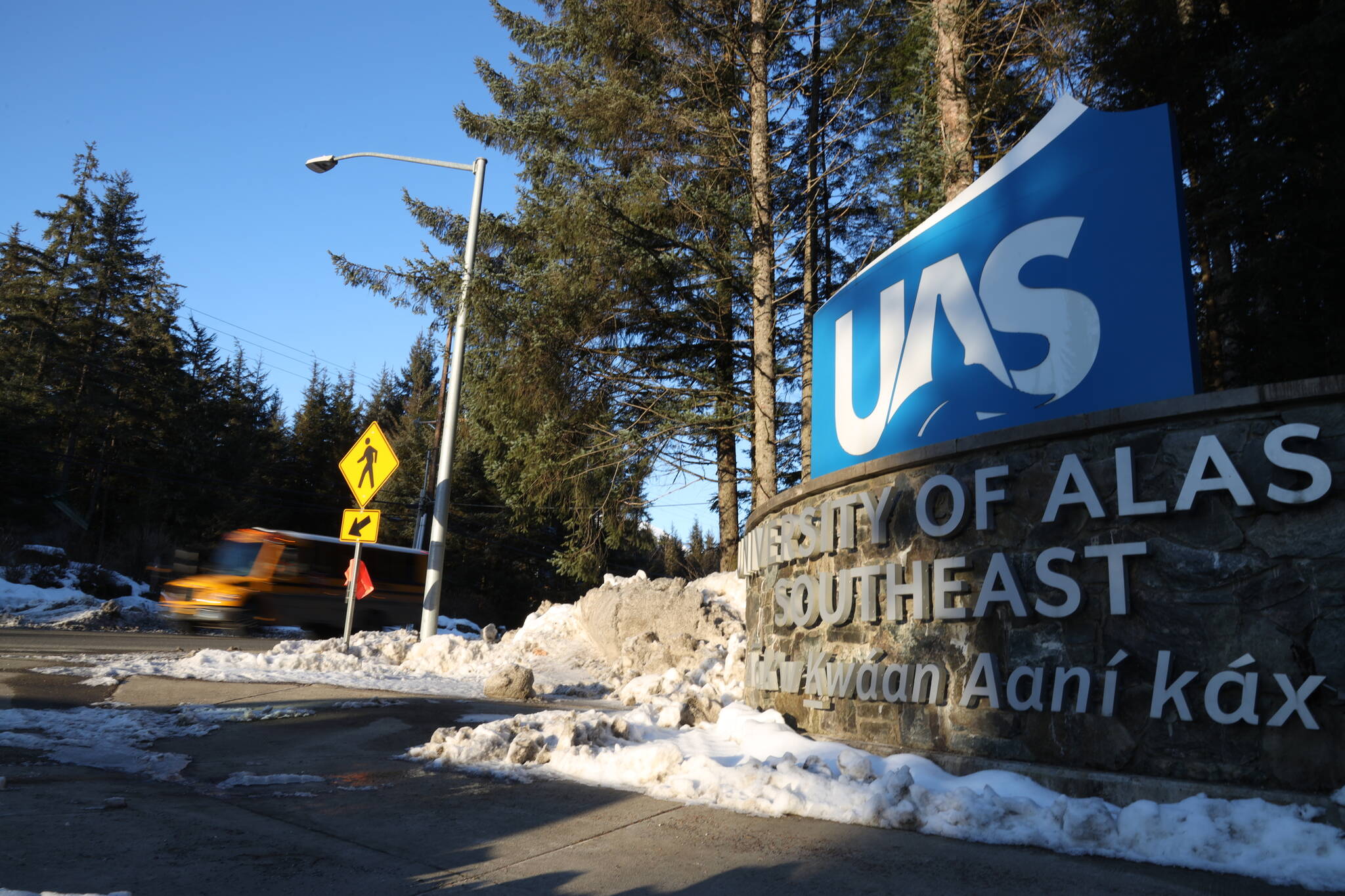 A school bus drives past the entrance of The University of Alaska Southeast on Tuesday afternoon. Pat Pitney, president of the statewide university system, highlighted ongoing and new efforts to by campuses including UAS to lure students into the teaching programs and subsequently remain as public school teachers in the state. (Clarise Larson / Juneau Empire)