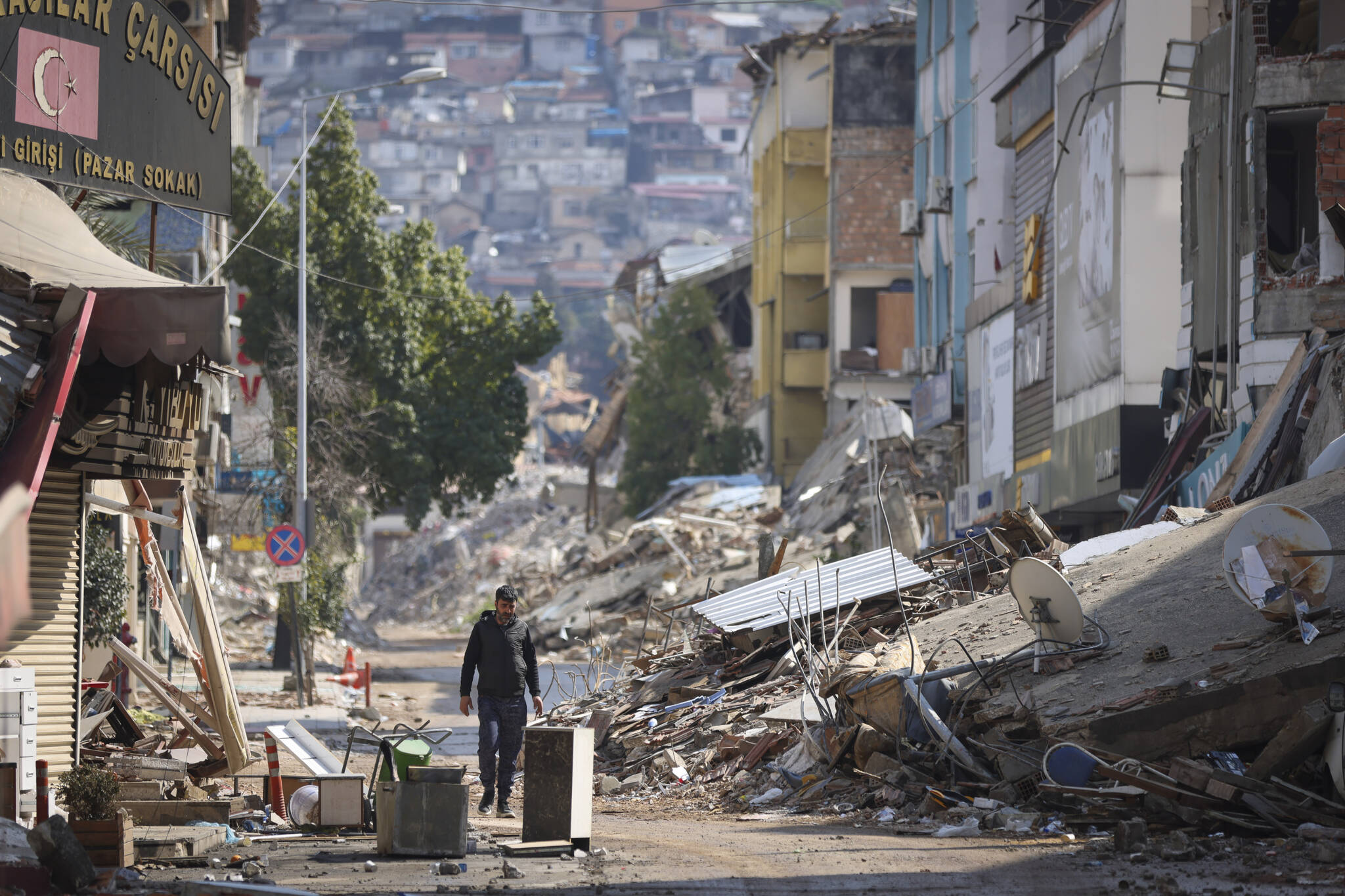 A man walks past destroyed buildings in Antakya, southeastern Turkey, Tuesday, Feb. 21, 2023. Douglas Mertz writes that the disaster offers lessons for Alaska’s capital city. (AP Photo / Unal Cam)