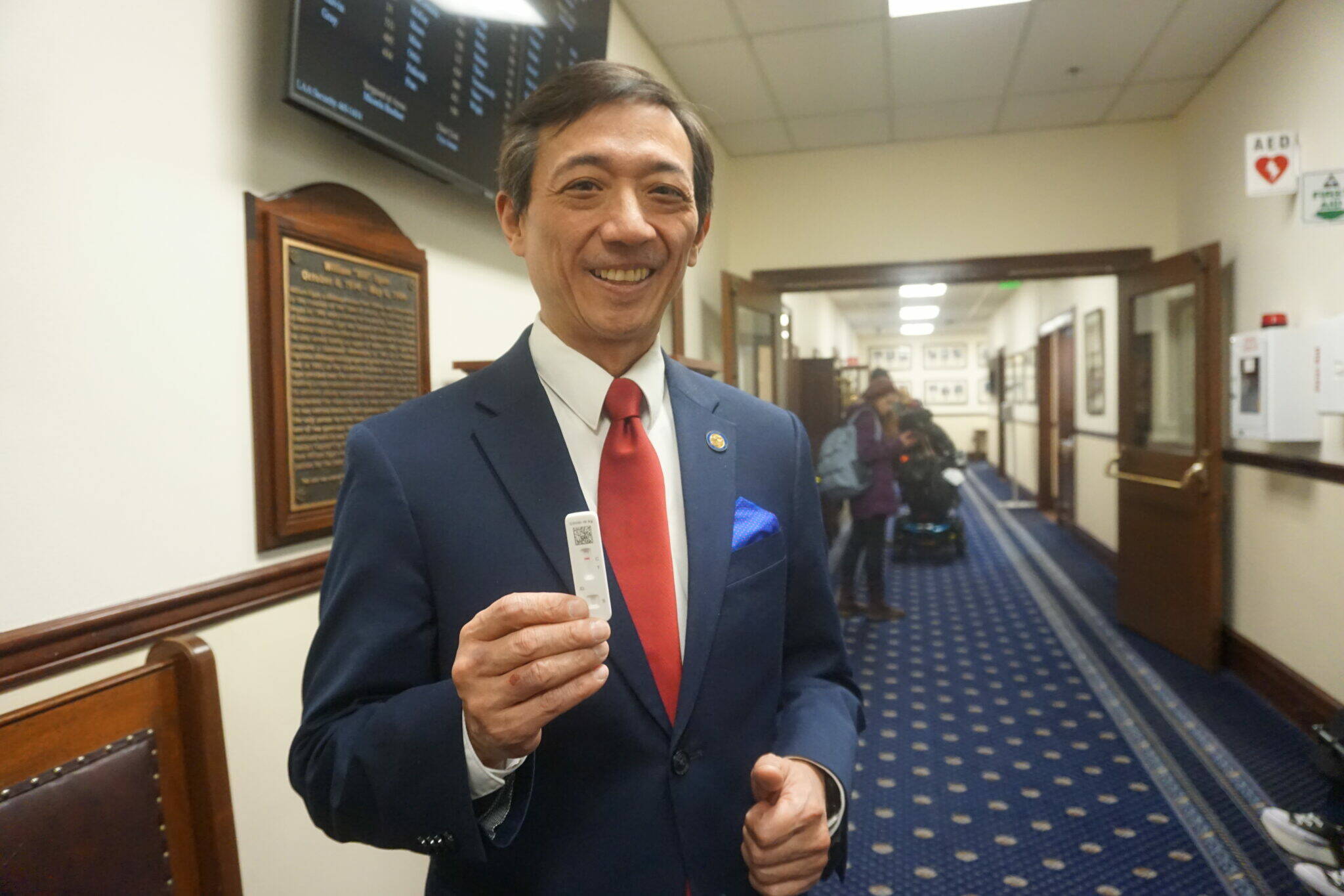 State Sen. Scott Kawasaki, in a hallway in the Alaska State Capitol on Feb. 16 holds up the strip showing he has tested negative for COVID-19. Kawasaki said he opted to take a test that day. (Yereth Rosen / Alaska Beacon)