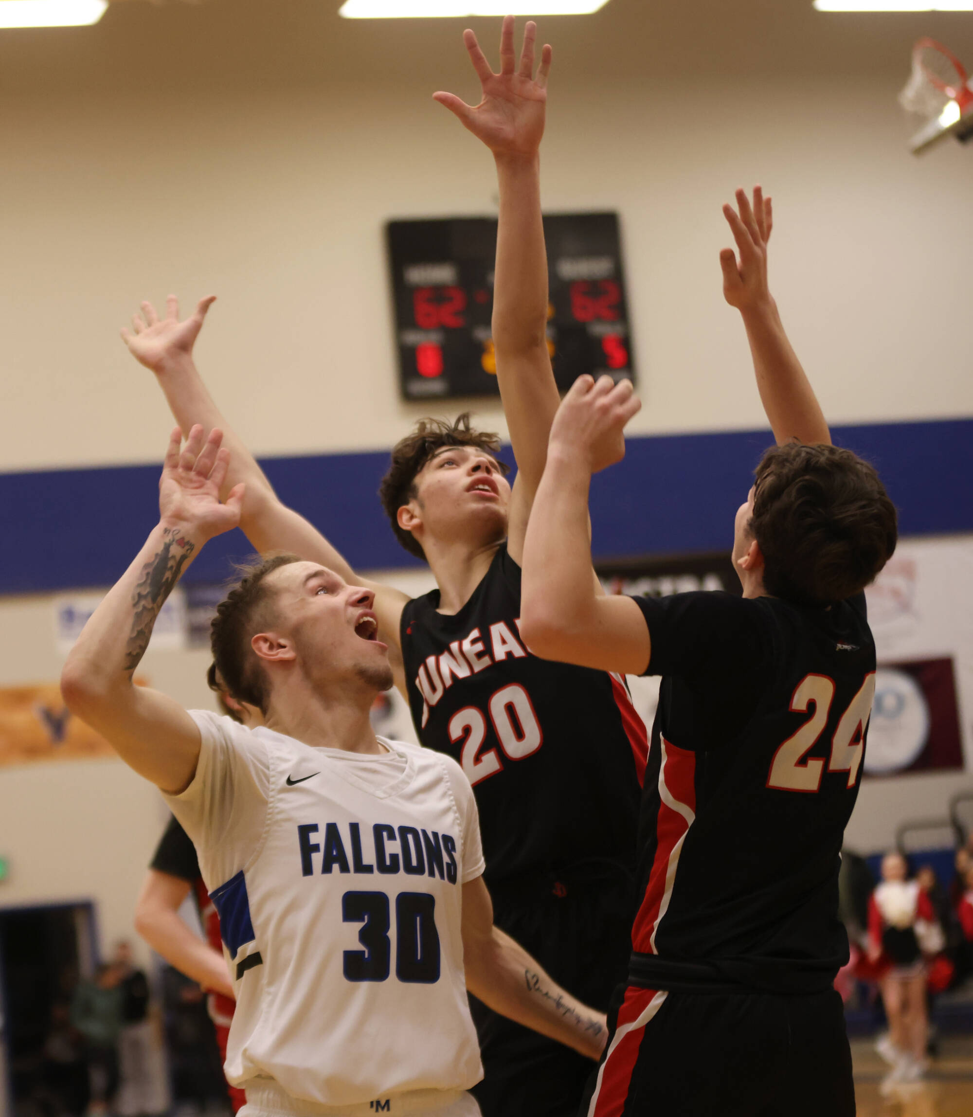 Ben Hohenstatt / Juneau Empire 
TMHS junior Thomas Baxter (30) watches as his game-winning shot makes its way past the arms of JDHS senior Orion Dybdahl (20) and JDHS senior Kai Hargrave (24) who contested the shot closely.
