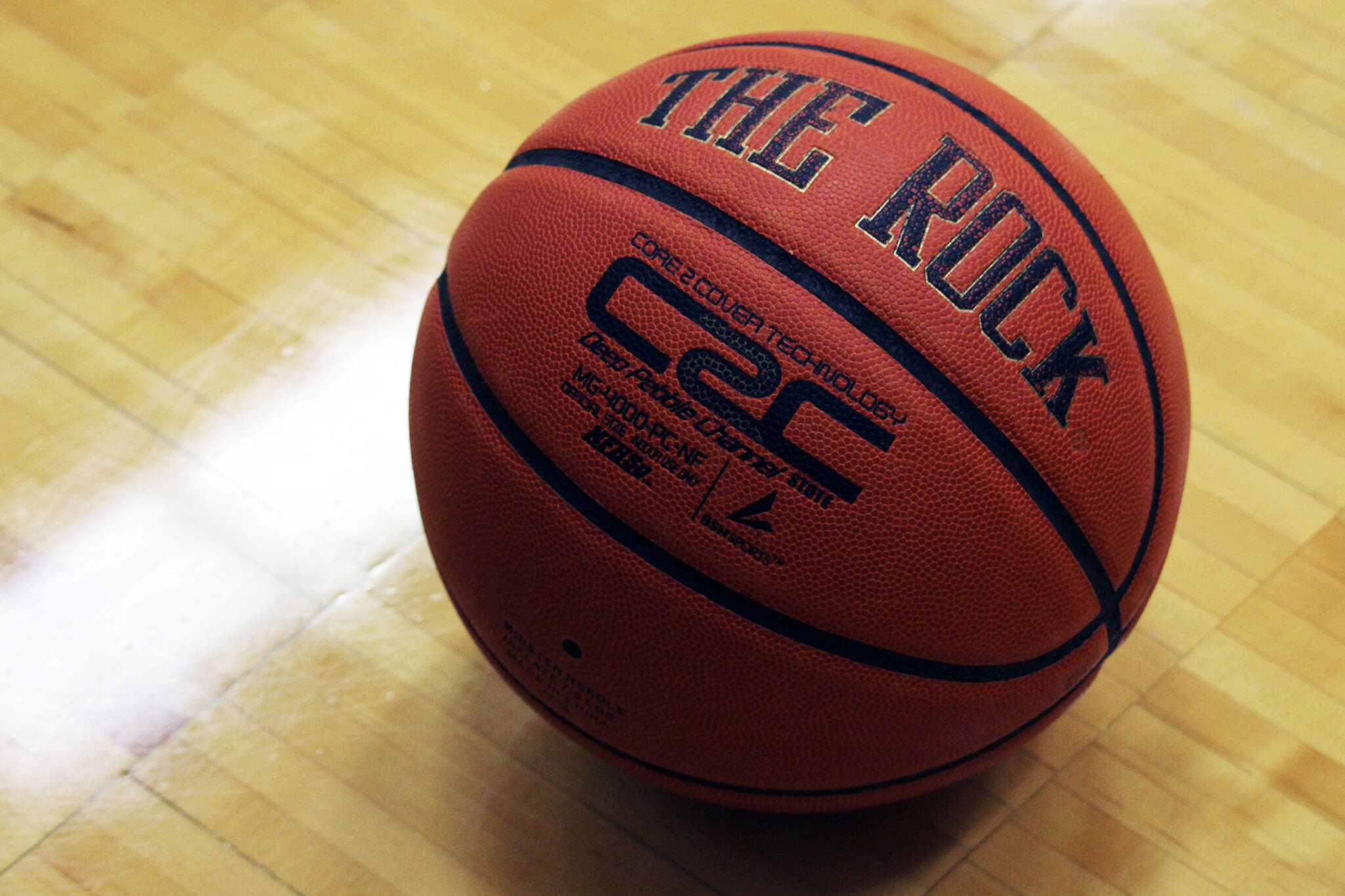 A high school basketball rests on a gym floor at Thunder Mountain High School, which this week will be the site of the 2A and 4A Region V tournaments. (Ben Hohenstatt / Juneau Empire File)
