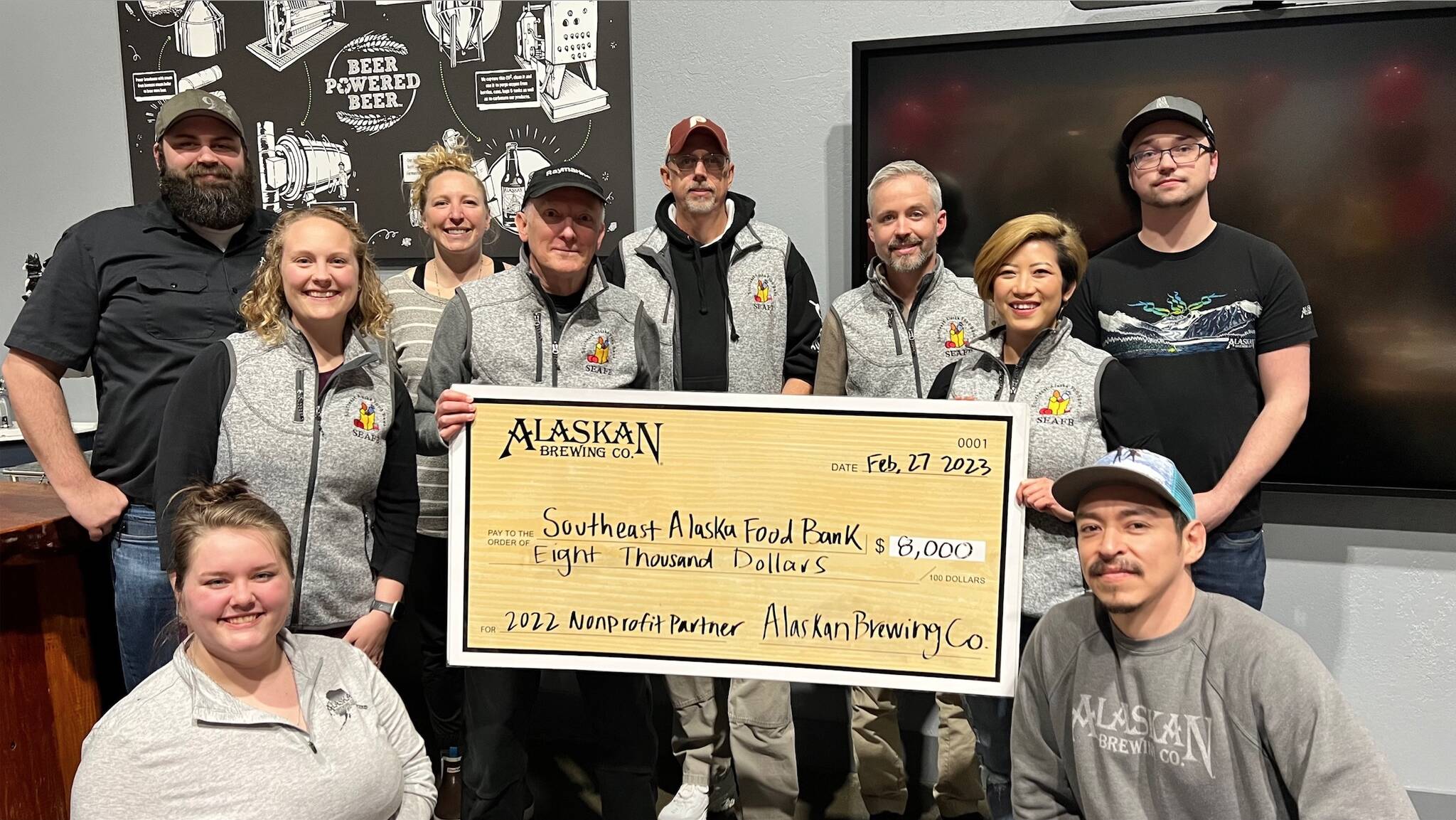 Alaskan Brewing Co. staff presents a check to Southeast Alaska Food Bank director Chris Schapp on Tuesday as part of the company’s “Cheers to the Southeast Alaska Food Bank!” celebration. The evening also celebrated the selection of Alaskan Brewing Co. next year recipient SEADOGS. (Courtesy Photo / Erin Youngstrom)