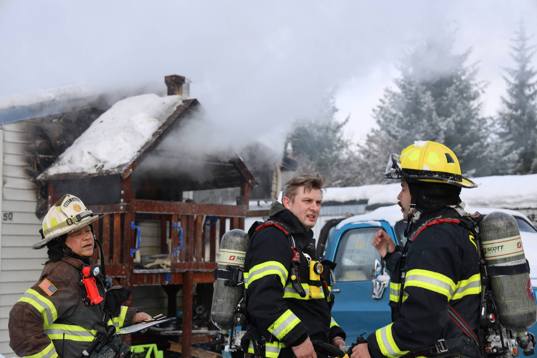 Capital City Fire/Rescue firefighters move to extinguish a trailer fire Friday morning. The cause of the fire is believed to be caused by an electric toaster, officials say. (Clarise Larson / Juneau Empire)