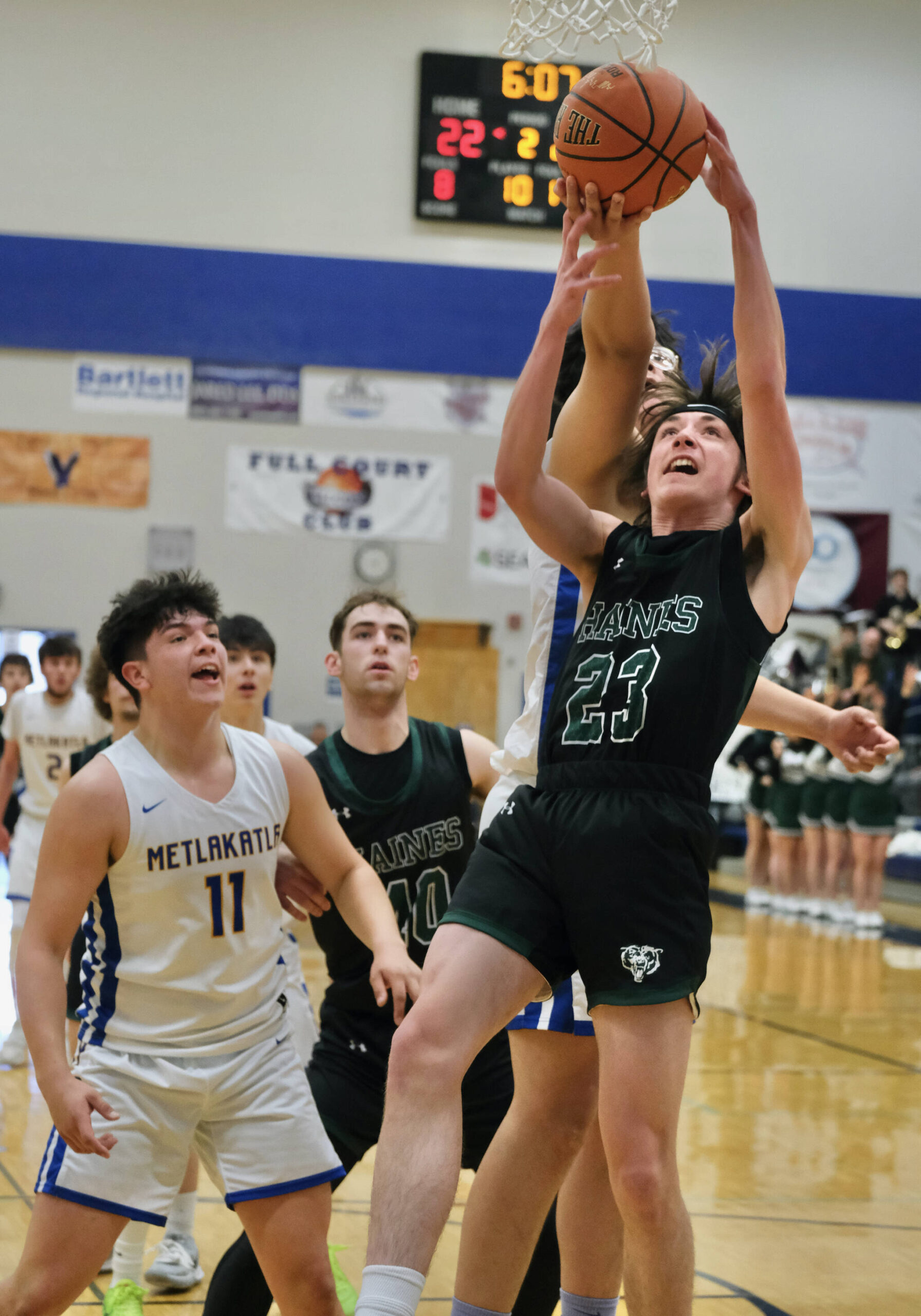 Metlakatla’s Aaron O’Brien takes a rebound from behind Haines’ Phoenix Swaner (23) during the Region V tournament on Thursday. (Klas Stolpe / For the Juneau Empire)