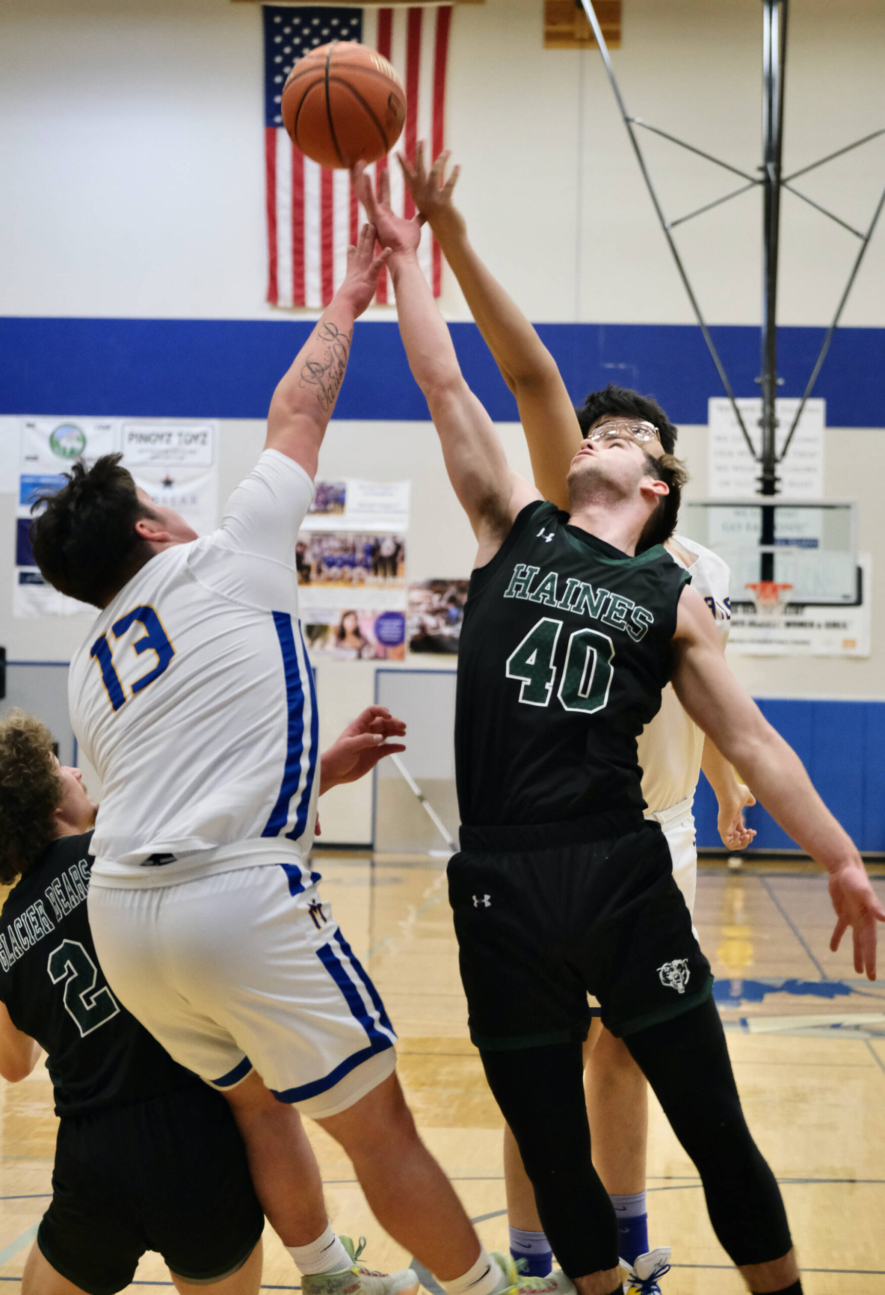 Metlakatla’s Cameron Gaube (13) and Aaron O’Brien battle for a rebound with Haines’ Luke Davis (2) and Eric Brouilette (40) during the Region V tournament on Thursday. (Klas Stolpe / For the Juneau Empire)