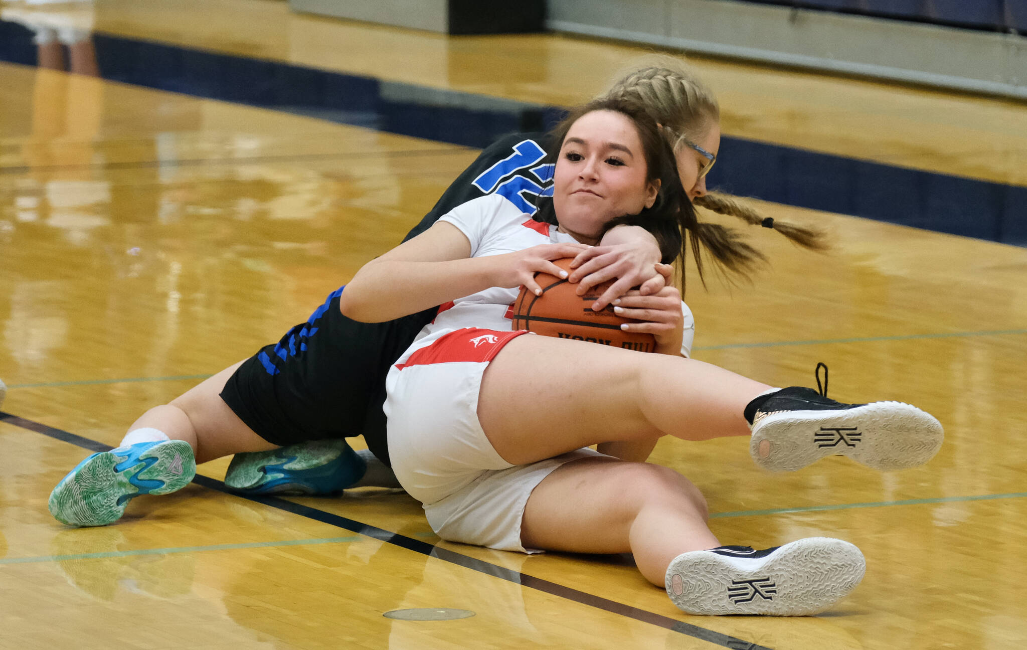Wrangell High School junior Kayla Meissner (23) and Petersburg High School sophomore Eleanor Kandoll (12) battle for a loose ball during the Lady Wolves’ 48-10 win over the Lady Vikings in the Region V 2A/4A Basketball Tournament on Wednesday at Thunder Mountain High School in Juneau. (Klas Stolpe for the Juneau Empire)