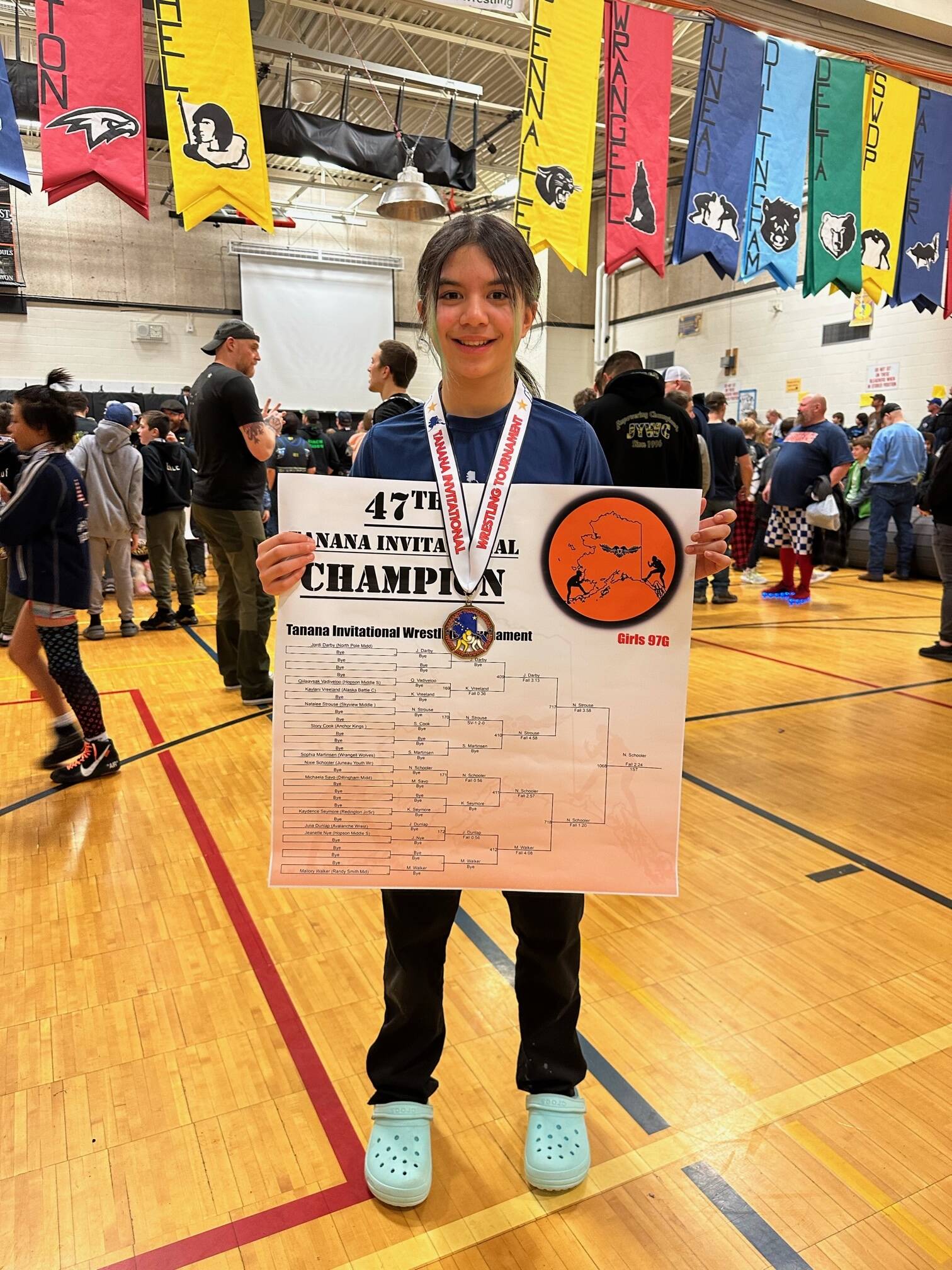 Nixie Schooler proudly displays her gold medal and winners bracket at the 47th annual Tanana Middle School Invitational in Fairbanks March 3-4. (Courtesy Photo / Eva Carrillo)