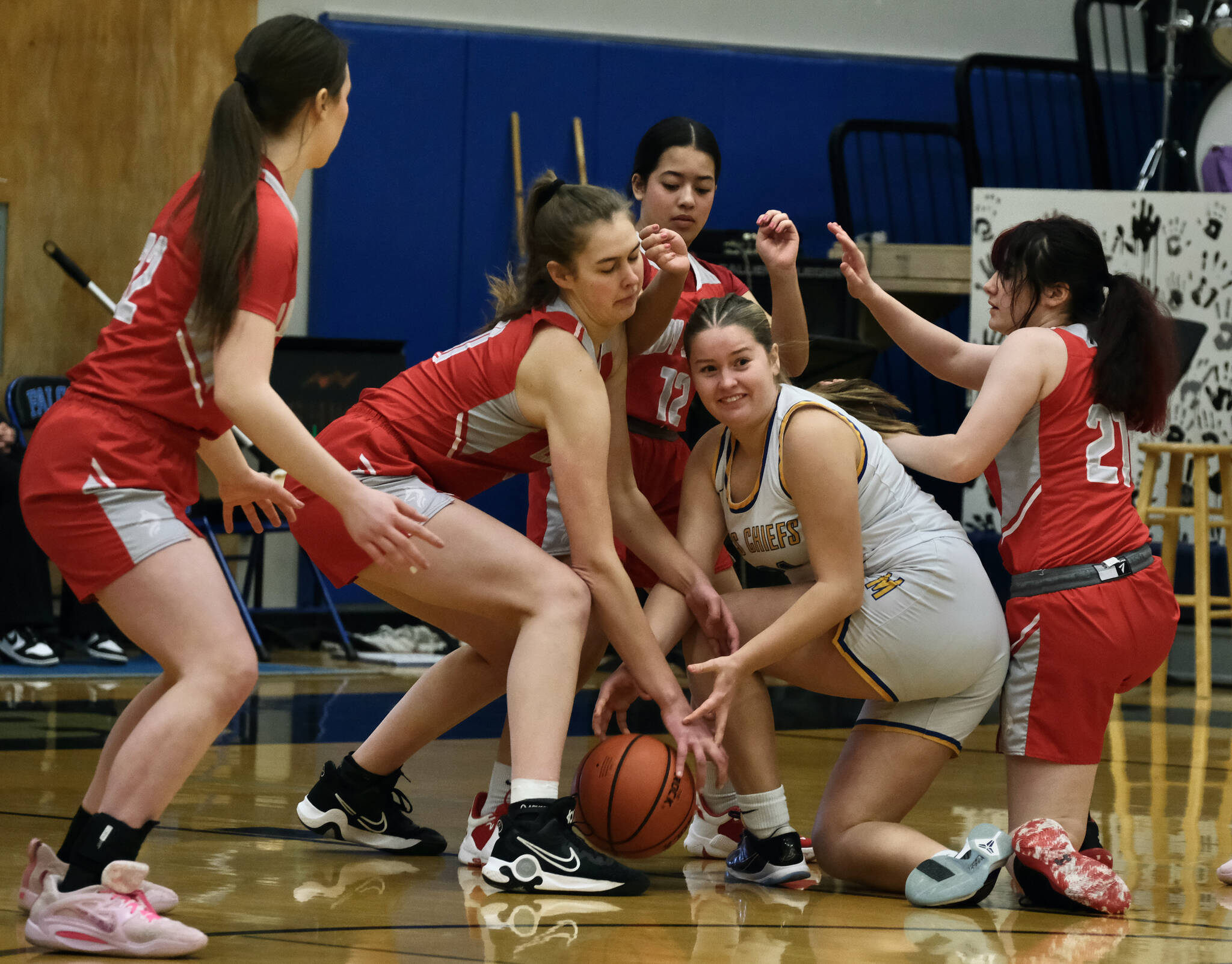Metlakatla junior Ryley Booth battles for a loose ball with Wrangell sophomore Aubrey Wynne, senior Kiara Harrison, freshman Christina Johnson (12) and sophomore Addy Andrews (21) in the Region V 2A/4A Basketball Tournament on Thursday at Thunder Mountain High School in Juneau. (Klas Stolpe / For the Juneau Empire)