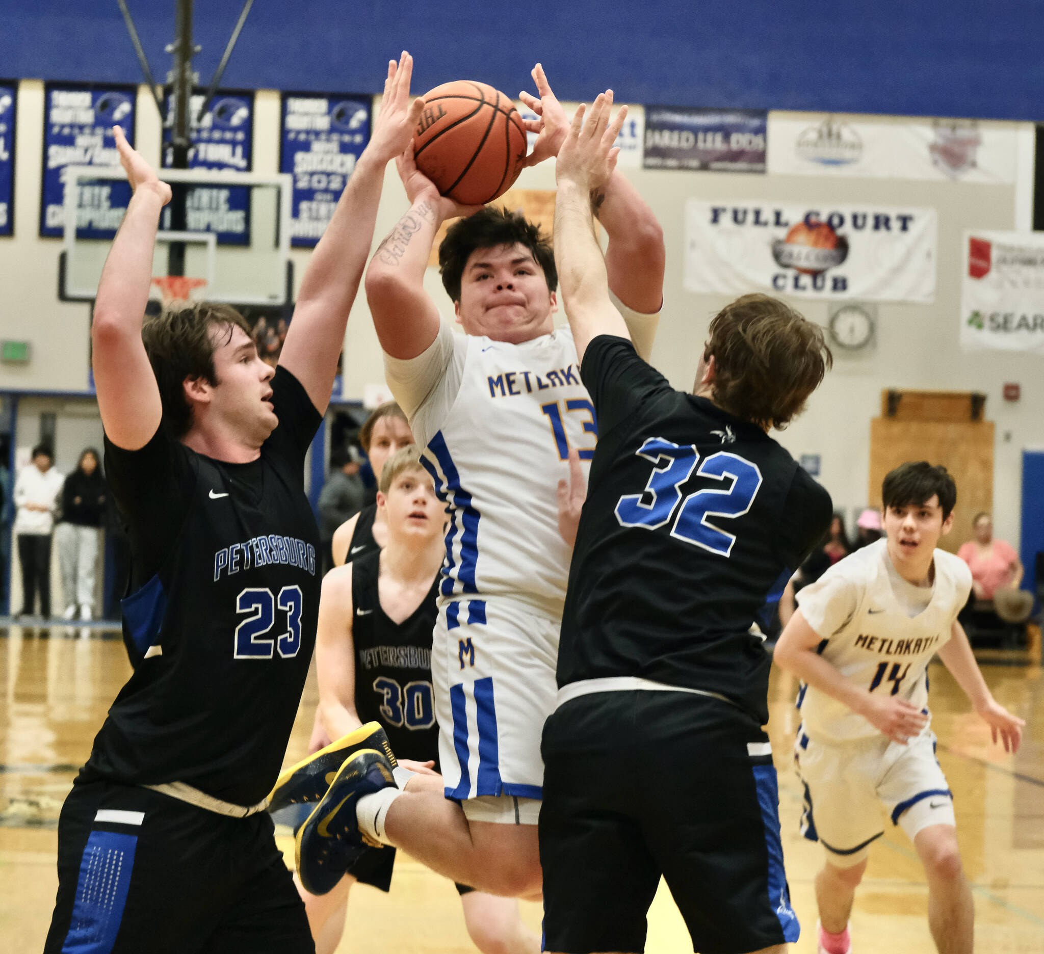 Metlakatla High School senior Cameron Gaube (13) shoots against Petersburg’s Kyle Biggers (23) and Jack Engell (32) during the Chiefs 2A Region V Championship game win over the Vikings on Friday at Juneau’s Thunder Mountain High School. (Klas Stolpe / For the Juneau Empire)