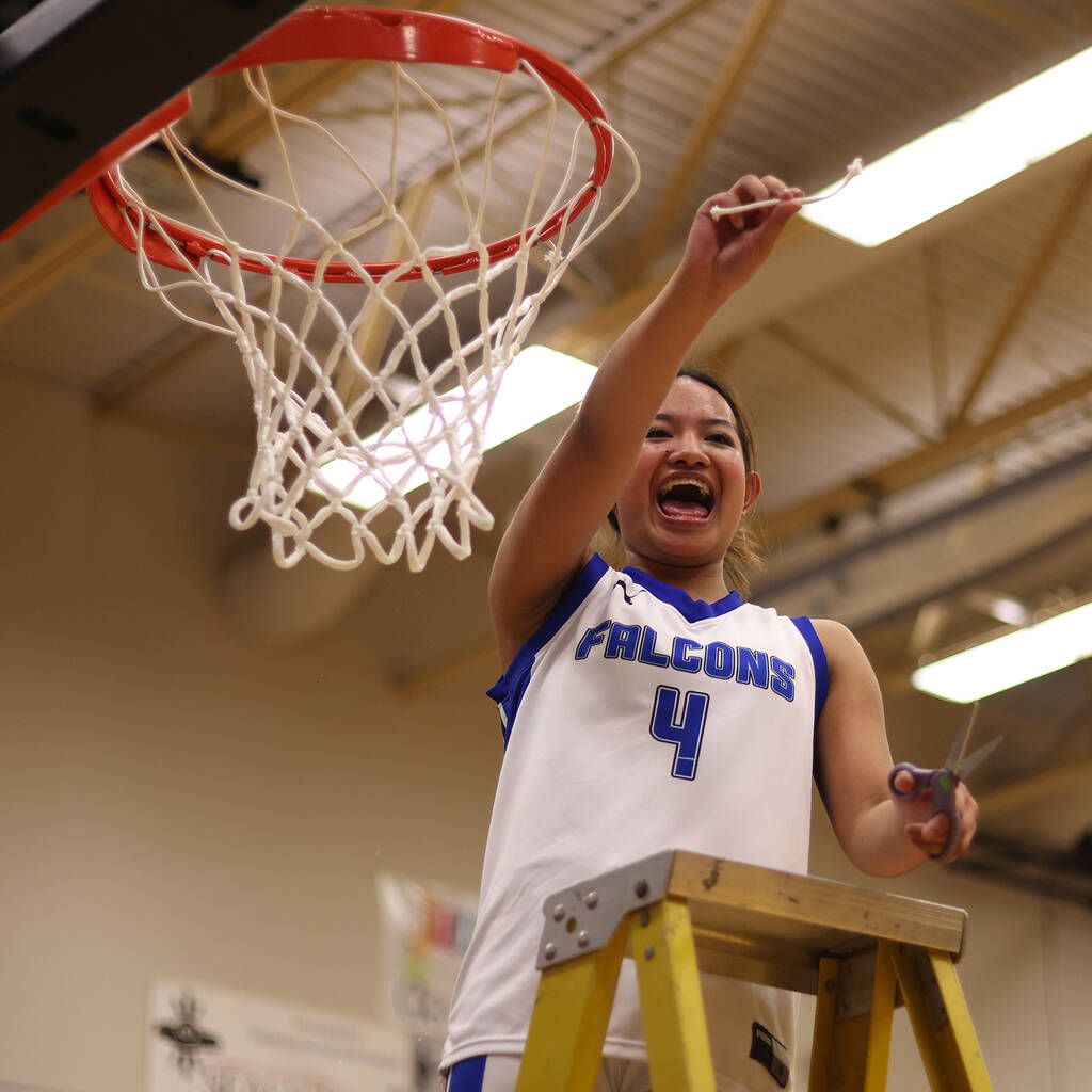 TMHS junior Mikah Carandang celebrates after cutting down here piece of the net following a 43-35 win in the Region V 4A Championship. (Ben Hohenstatt / Juneau Empire)