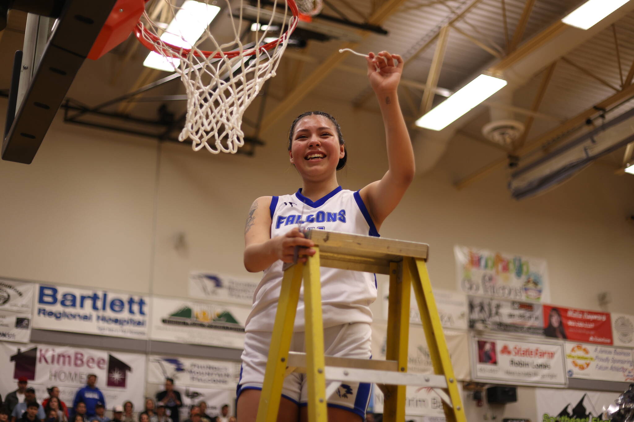 TMHS senior Kiara Kookesh holds up a strand from the net after securing the win against JDHS on Friday for the two teams’ final math up in the 4A Region V tournament. Kookesh tied for the lead in scoring with a total of 12 points. (Ben Hohenstatt / Juneau Empire)