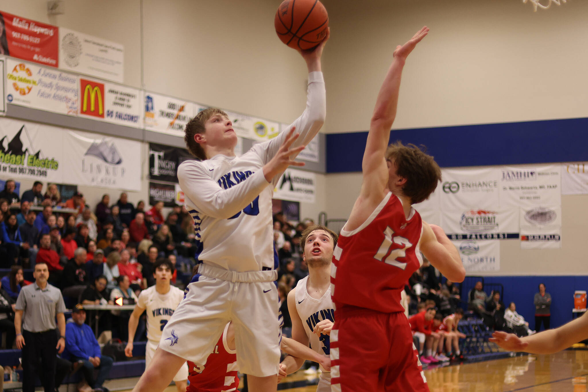 Petersburg junior Hunter Conn puts up a shot over Wrangell senior Ethan Blatchley as part of a play that briefly gave the Vikings a slim lead against the Wolves. However, Wrangell would answer back and go on to secure a berth to state. (Ben Hohenstatt / Juneau Empire)