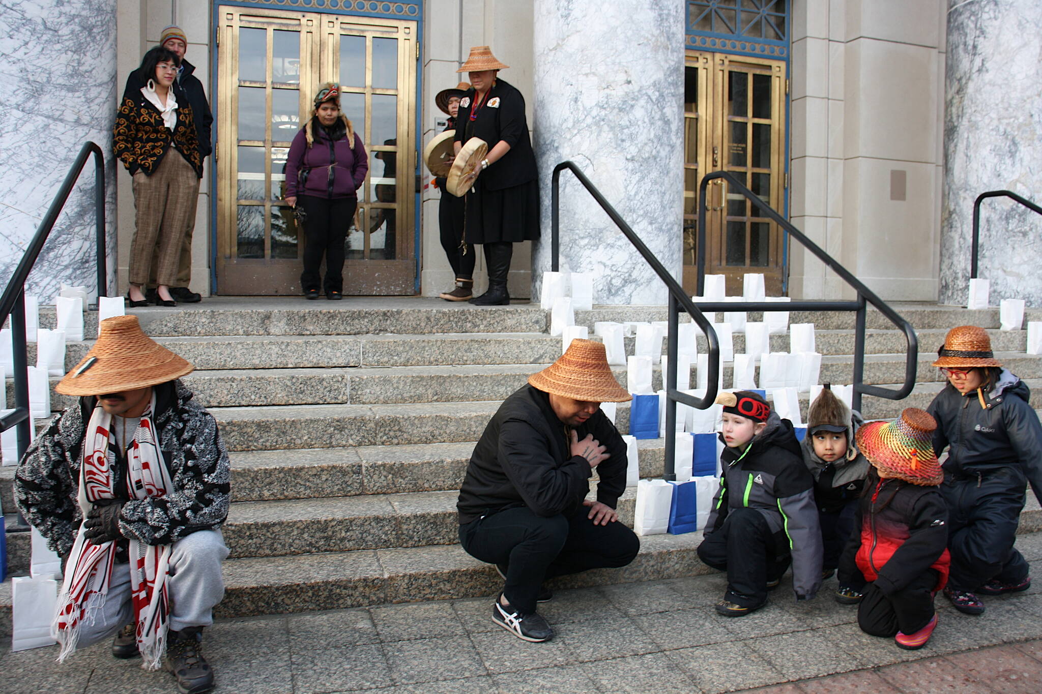 The Woosh.ji.een Dance Group performs amongst 220 candles in paper bags on the steps of the Alaska State Capitol on Tuesday evening during a vigil to recognize residents who have died by suicide. The candles represent each of the 220 suicides in 2021, with the blue bags representing people who served in the military. (Mark Sabbatini / Juneau Empire)