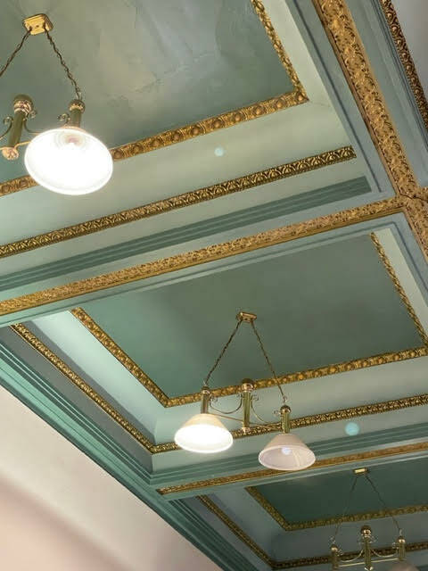 This 2023 interior photo shows the renovated original coffered ceiling inside Juneau Drug in the historic Valentine Building. Prior to the 1980s renovation, the ornate ceiling was hidden behind a drop ceiling. Along with other features of the 1900s building, owners Tom and Gail Findley restored the structure to much of its original Victorian architectural beauty. (Laurie Craig / For the DBA)