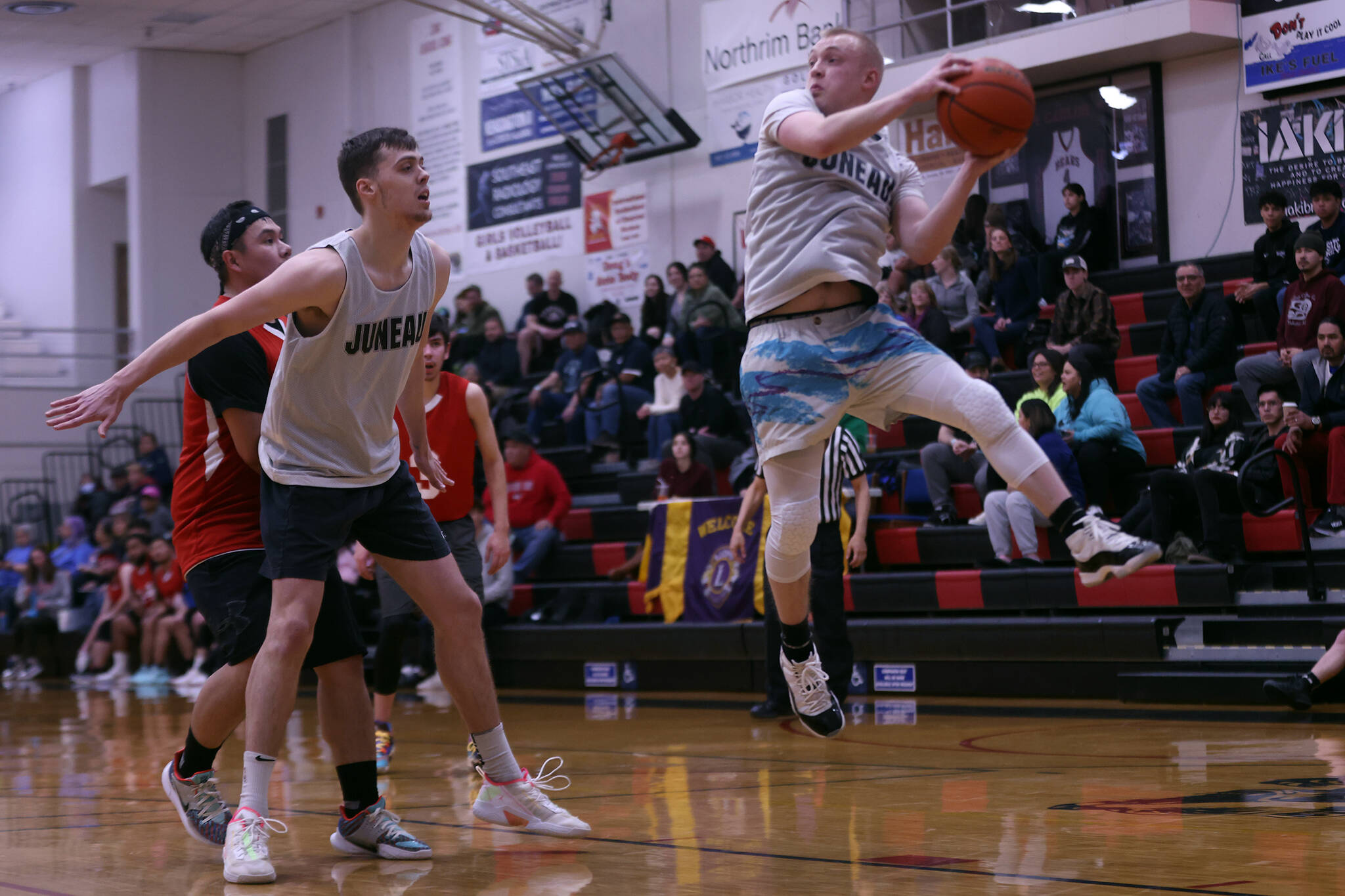 Juneau’s Kaleb Tompkins boxes out while teammate Chase Saviers comes down with a rebound in the first half of a Juneau win against Kake in the first round of the Gold Medal Basketball Tournament. (Ben Hohenstatt / Juneau Empire)