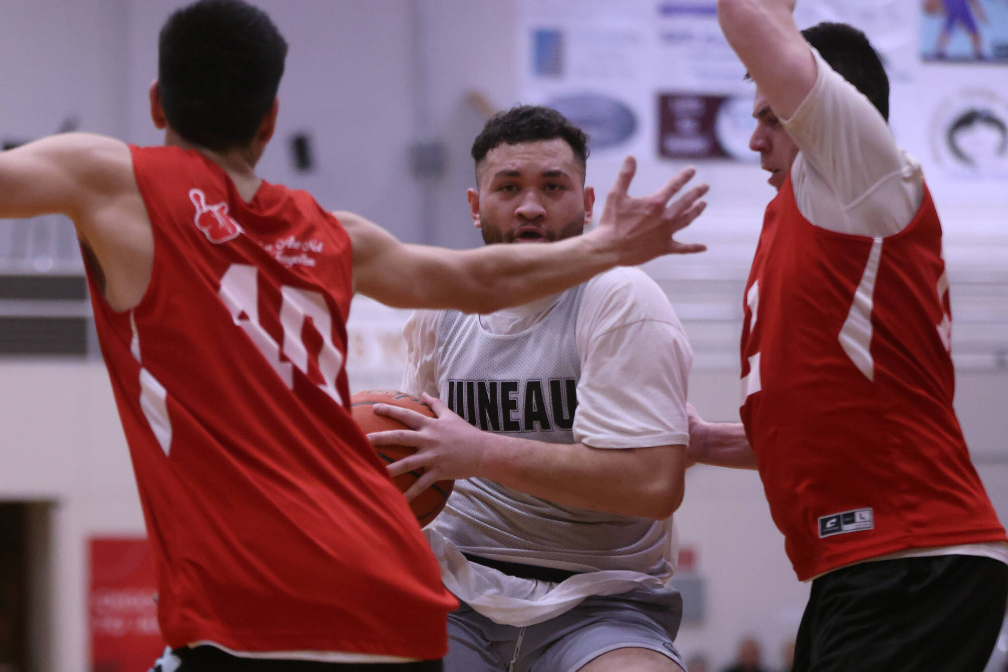 Juneau's Mahina Toutaiolepo peers through the arms of Kake defenders during the second half of a Juneau win in the Juneau Lions Club's 74th Gold Medal Basketball Tournament. (Ben Hohenstatt / Juneau Empire)