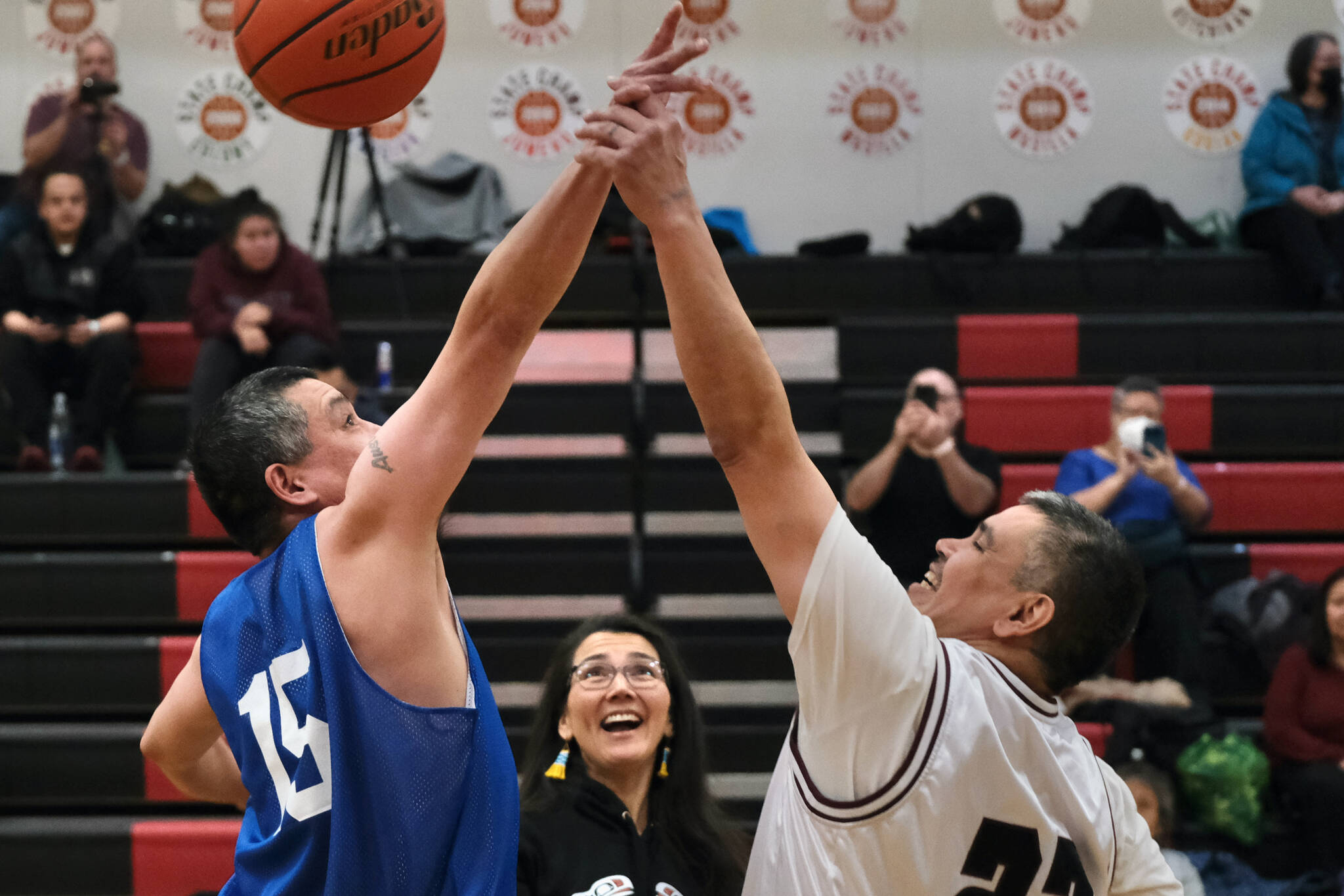 U.S. Rep. Mary Peltola put up the ceremonial jump ball for Kake's Rich Austin (15) and Hoonah's Albert Hinchman (22) during their Masters Bracket game in the Juneau Lions Club 74th Annual Gold Medal Basketball Tournament, Sunday, March 19, at the Juneau-Douglas High School: Yadaa.at Kalé gymnasium. (Klas Stolpe / For the Juneau Empire)
