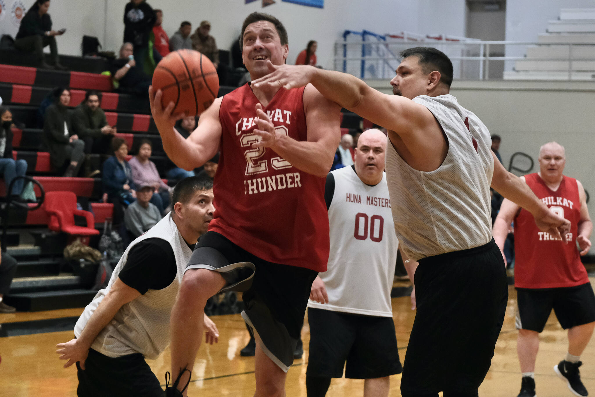 Klukwan’s Russ Stevens (23) scores against Hoonah’s Michael Mills (1) during Masters Bracket action in the Gold Medal Basketball Tournament, Monday, March 20, at Juneau-Douglas High School: Yadaa.at Kalé. (Klas Stolpe/For the Juneau Empire)