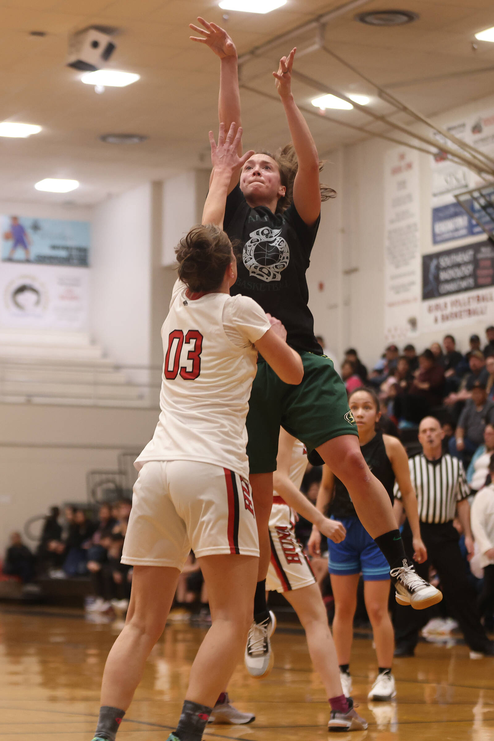 Prince of Wales’ Nani Weimer shoots over Hoonah’s Tanya Nizich (3) during a Prince of Wales win in the women’s bracket of the Gold Medal Basketball Tournament. The Prince of Wales-Hoonah game was the last game of the tournament’s second day. (Ben Hohenstatt / Juneau Empire)