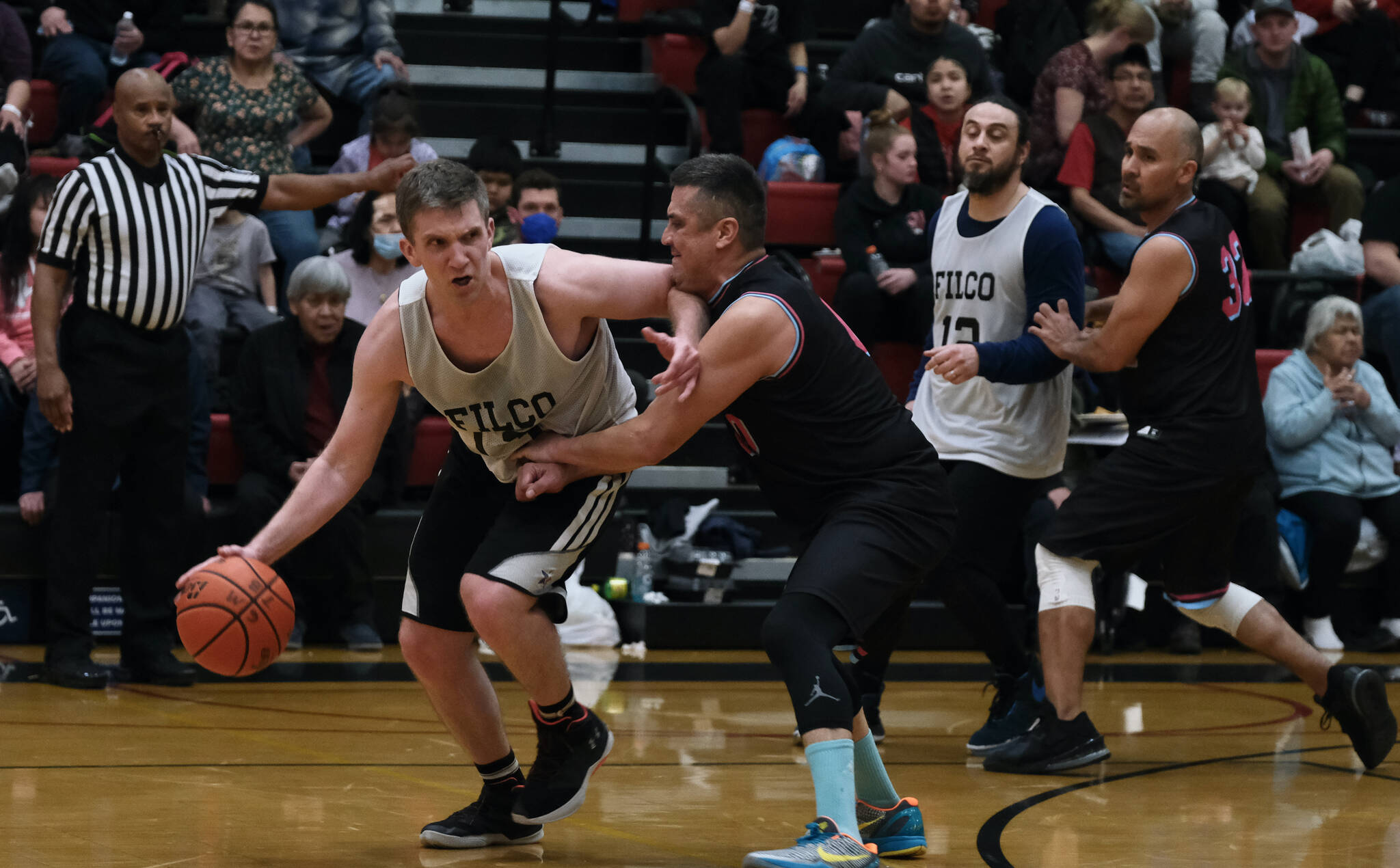 Filcom’s Tom Gisler dribbles under pressure from Hoonah’s Anthony Lindoff during C Bracket action in the Gold Medal Basketball Tournament, Monday, March 20, at Juneau-Douglas High School: Yadaa.at Kalé. (Klas Stolpe/For the Juneau Empire)