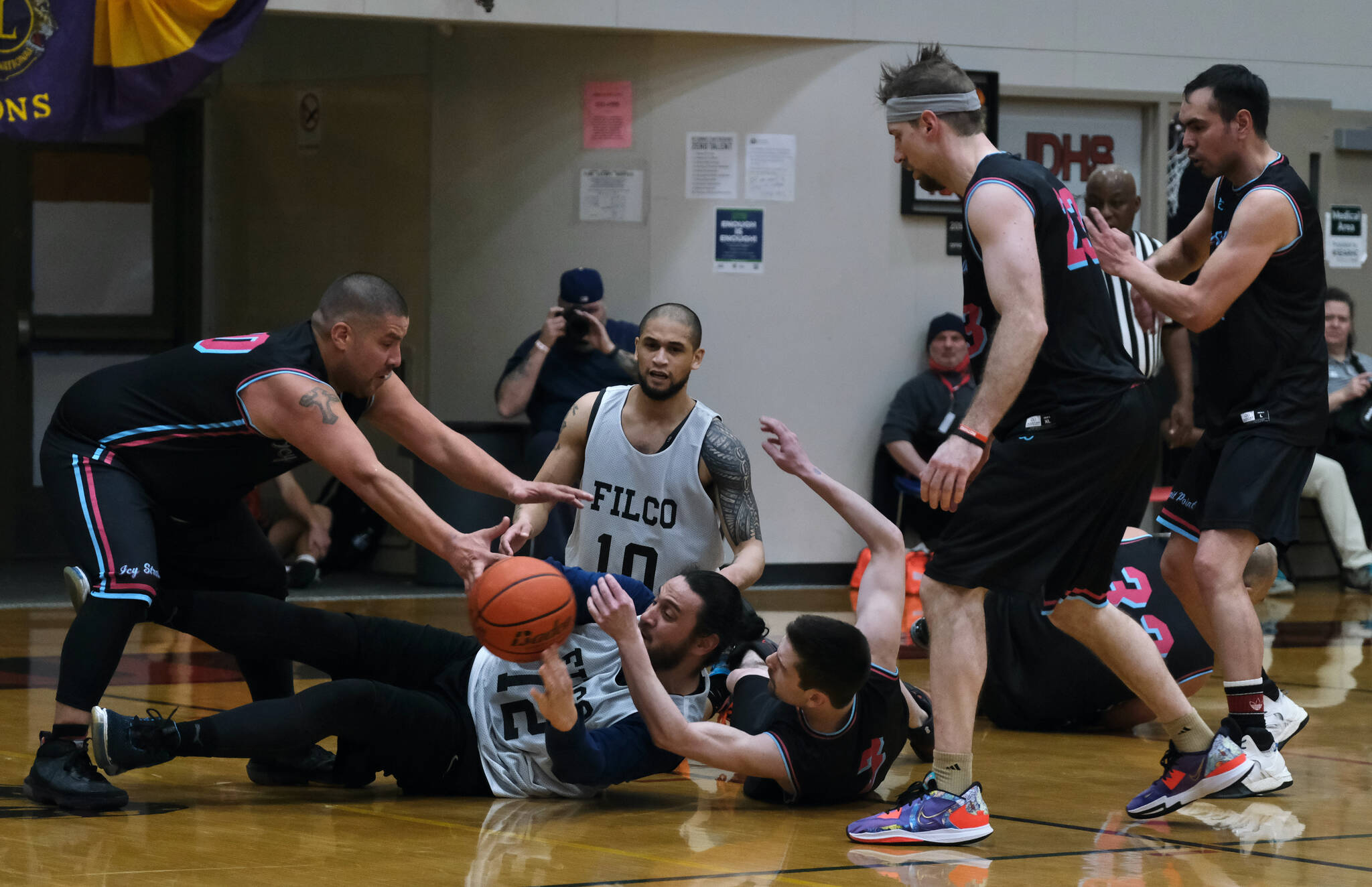 Hoonah and Filcom players battle for a loose ball during C Bracket action in the Gold Medal Basketball Tournament, Monday, March 20, at Juneau-Douglas High School: Yadaa.at Kalé. (Klas Stolpe/For the Juneau Empire)