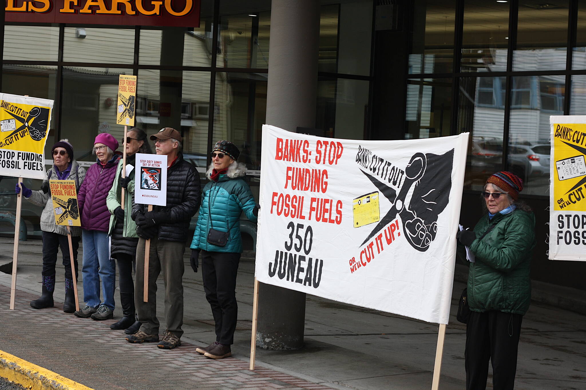 About 25 protesters gather outside the Wells Fargo branch in downtown Juneau at midday Tuesday, calling upon banks to halt financing of fossil fuel development projects. (Mark Sabbatini / Juneau Empire)