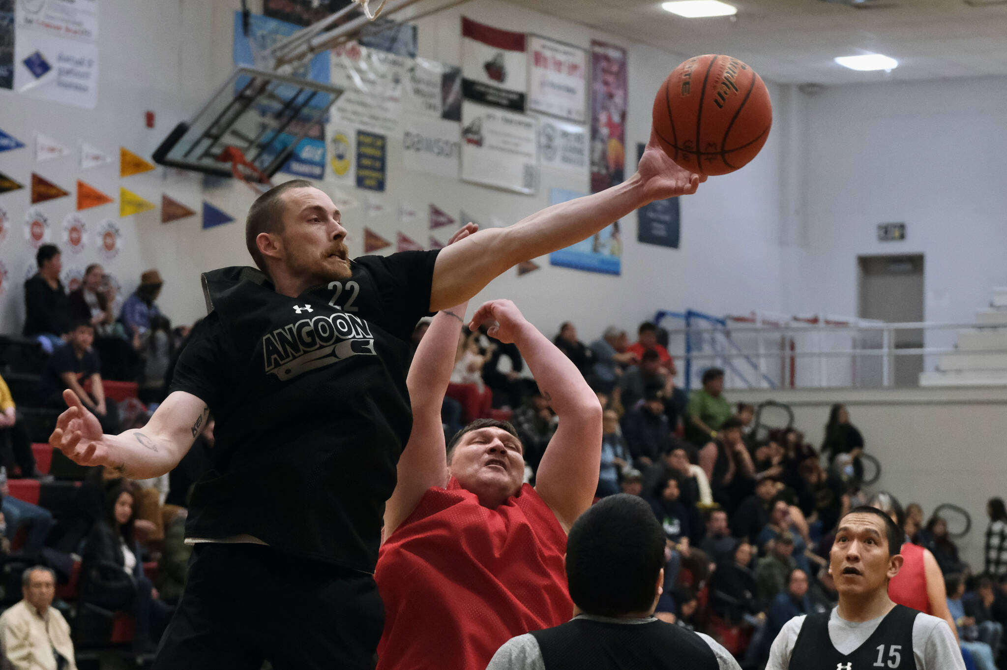 Angoon’s Ivan Raney (22) reaches for a rebound over Kake’s Jess Ross during C Bracket action in the Gold Medal Basketball Tournament, Tuesday, March 21, at Juneau-Douglas High School: Yadaa.at Kalé. (Klas Stolpe/For the Juneau Empire)