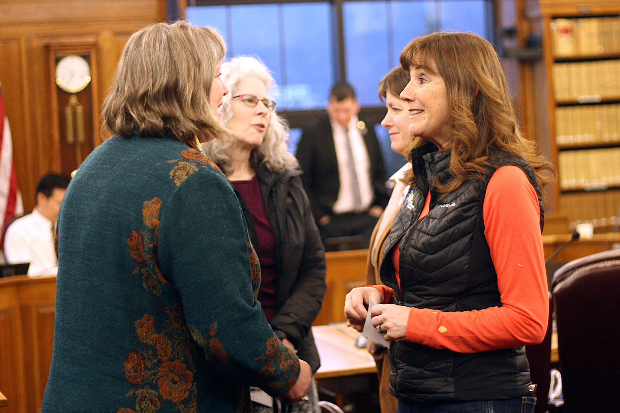 Rep. Sara Hannan, left, a Juneau Democrat on the House Finance Committee, and Juneau School District Superintendent Bridget Weiss talk during a break in a committee hearing Tuesday night featuring testimony from local residents about next year’s proposed state budget. (Mark Sabbatini / Juneau Empire)