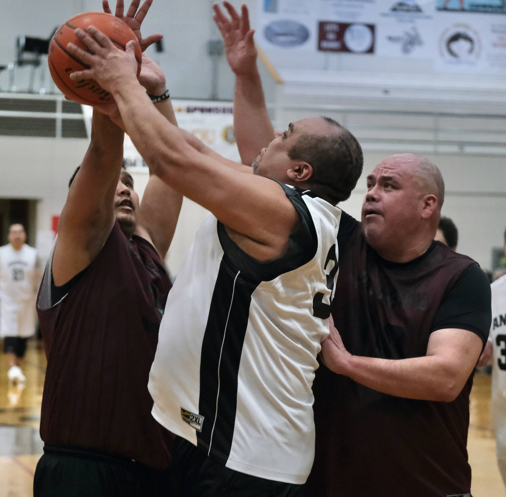 Angoon’s Albert Kookesh shoots against Hoonah’s Gary Smith and Andy Gray during the Gold Medal tournament, Wednesday, March 22, at Juneau-Douglas High School: Yadaa.at Kalé. (Klas Stolpe/For the Juneau Empire)