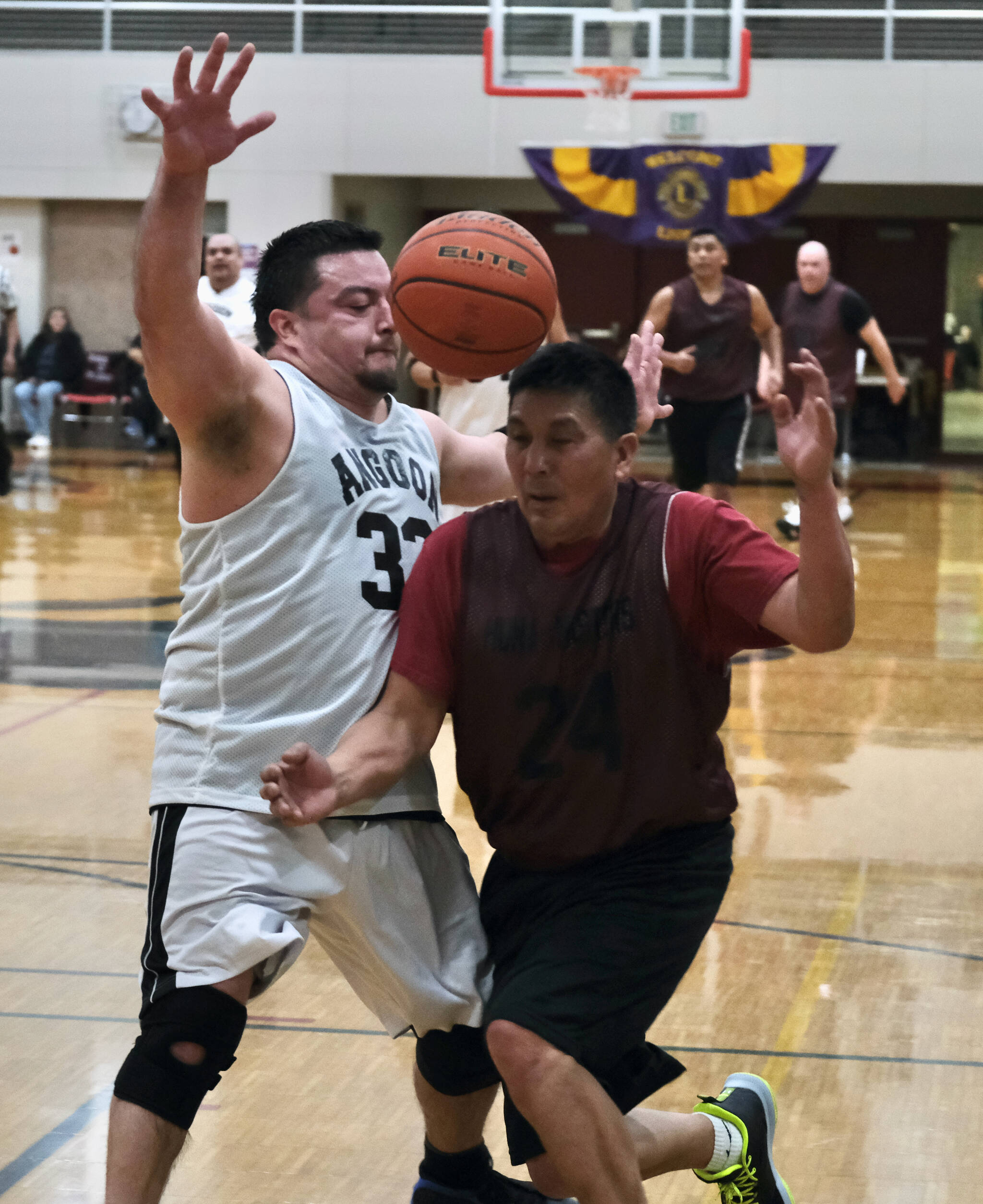 Angoon’s David Johnson (32) fouls Hoonah’s Kenny Willard (24) during the Gold Medal tournament, Wednesday, March 22, at Juneau-Douglas High School: Yadaa.at Kalé. (Klas Stolpe/For the Juneau Empire)