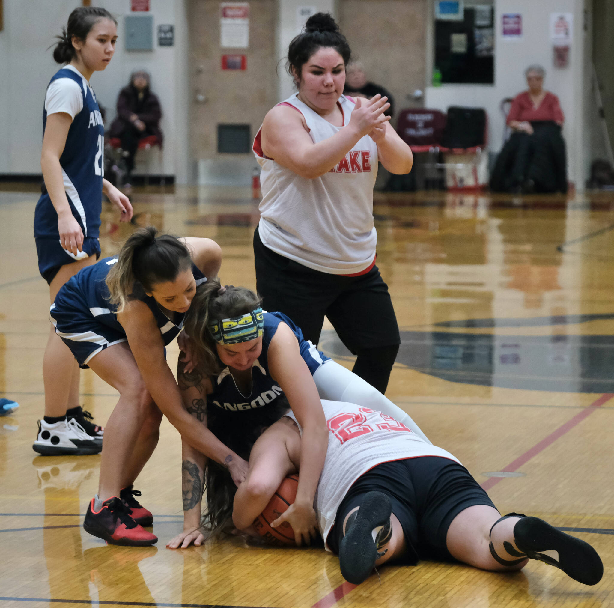 Kake’s Monica Ashenfelter signals for a timeout as teammate Janessa Ashenfelter battles for a loose ball with Angoon’s Carmeleeda Estrada and Ladonna Byers during Thursday action at the Juneau Lions Club 74th Annual Gold Medal Basketball Tournament at Juneau-Douglas High School: Yadaa.at Kalé. (Klas Stolpe/For the Juneau Empire)