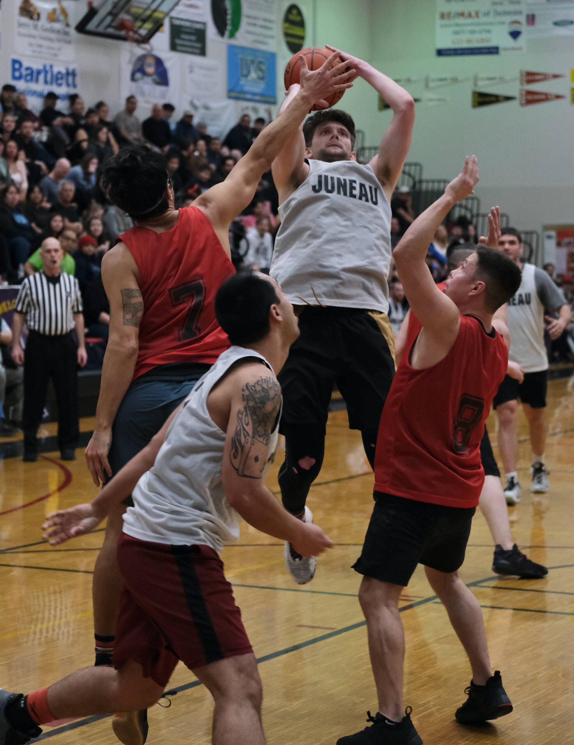 Juneau’s Matt Seymour shoots over Hydaburg’s Claude Young (7) and Vinnie Edenshaw (8) during Thursday’s B Bracket semifinal in the Juneau Lions Club 74th Annual Gold Medal Basketball Tournament at Juneau-Douglas High School: Yadaa.at Kalé. (Klas Stolpe/For the Juneau Empire)