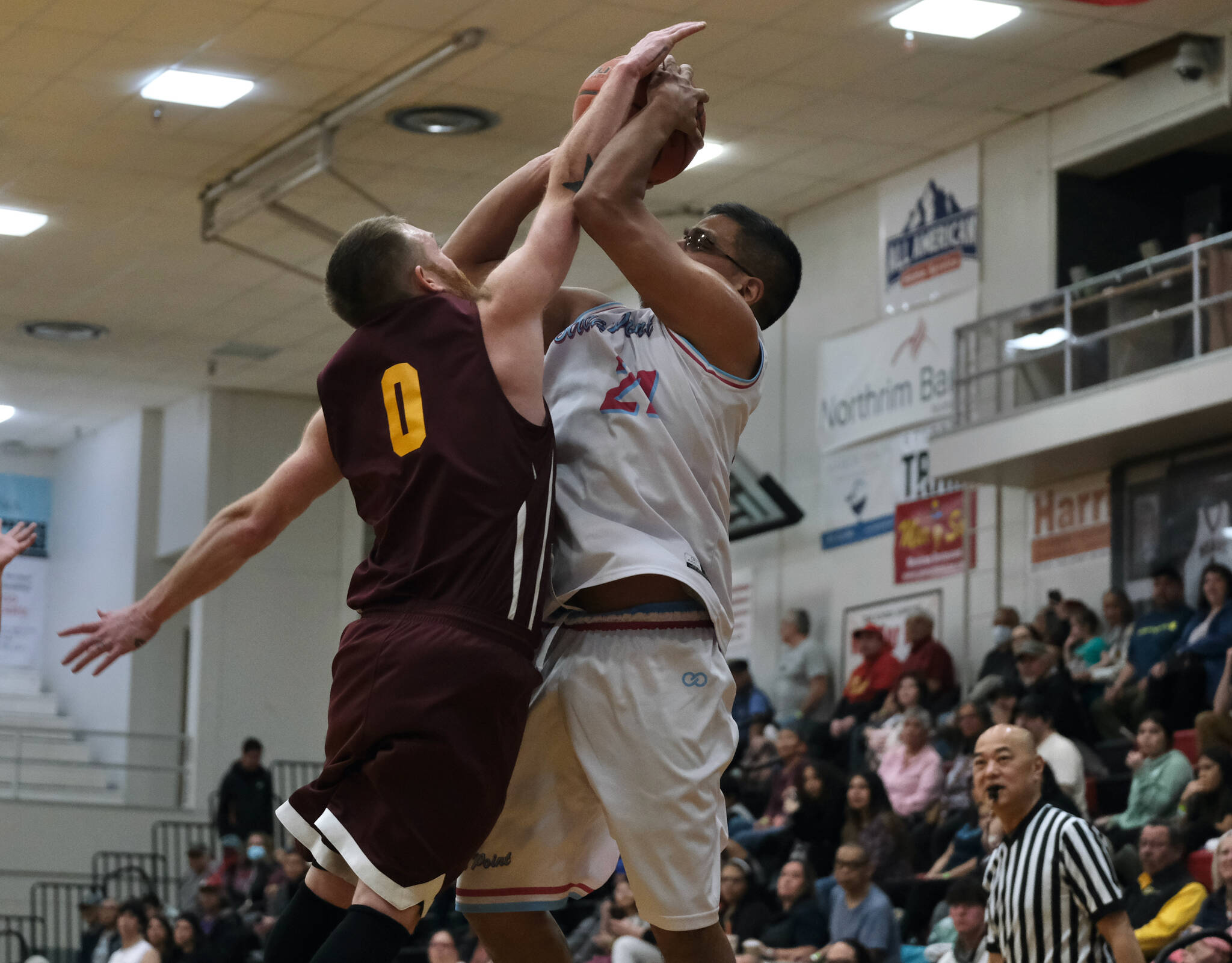 Klukwan's Daniel Stickler (0) defends a shot by Hoonah's Lucas Johnson (21) during Friday's C Bracket elimination game. Klukwan won 78-65 and will play Juneau Filcom in Saturday's championship. (Klas Stolpe/For the Juneau Empire)