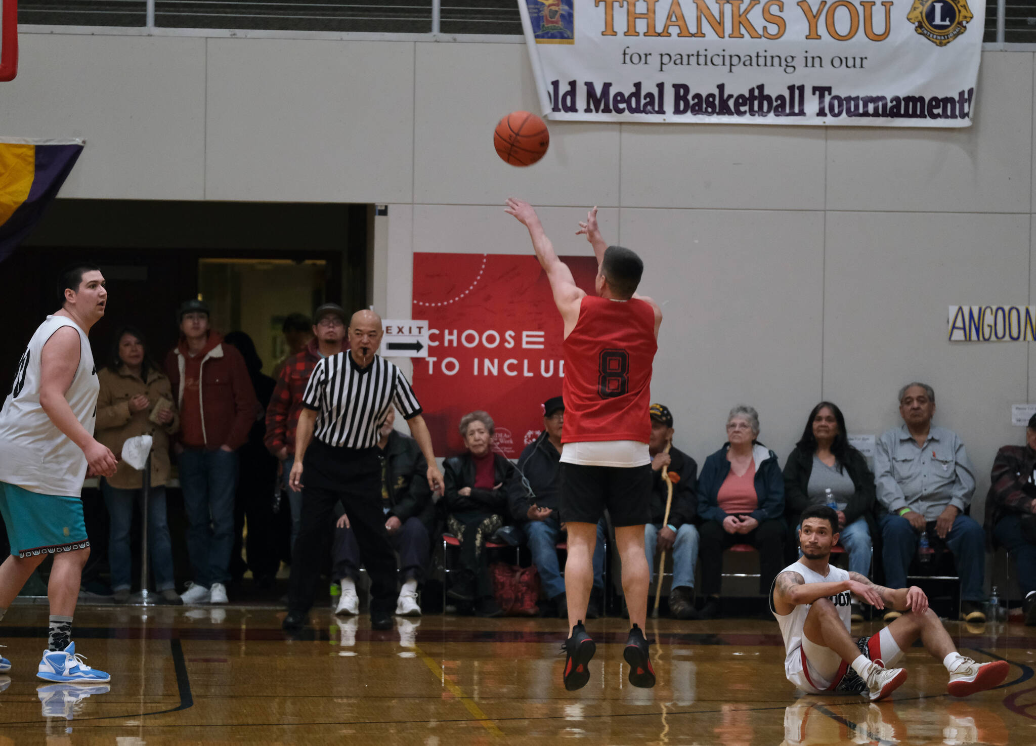 Hydaburg’s Vinnie Edenshaw (8) hits a three-point shot while Angoon’s Kendrick Payton (left) and Aquino Brinson (right) look on during Saturday’s B Bracket double-overtime elimination game. (Klas Stolpe/For the Juneau Empire)