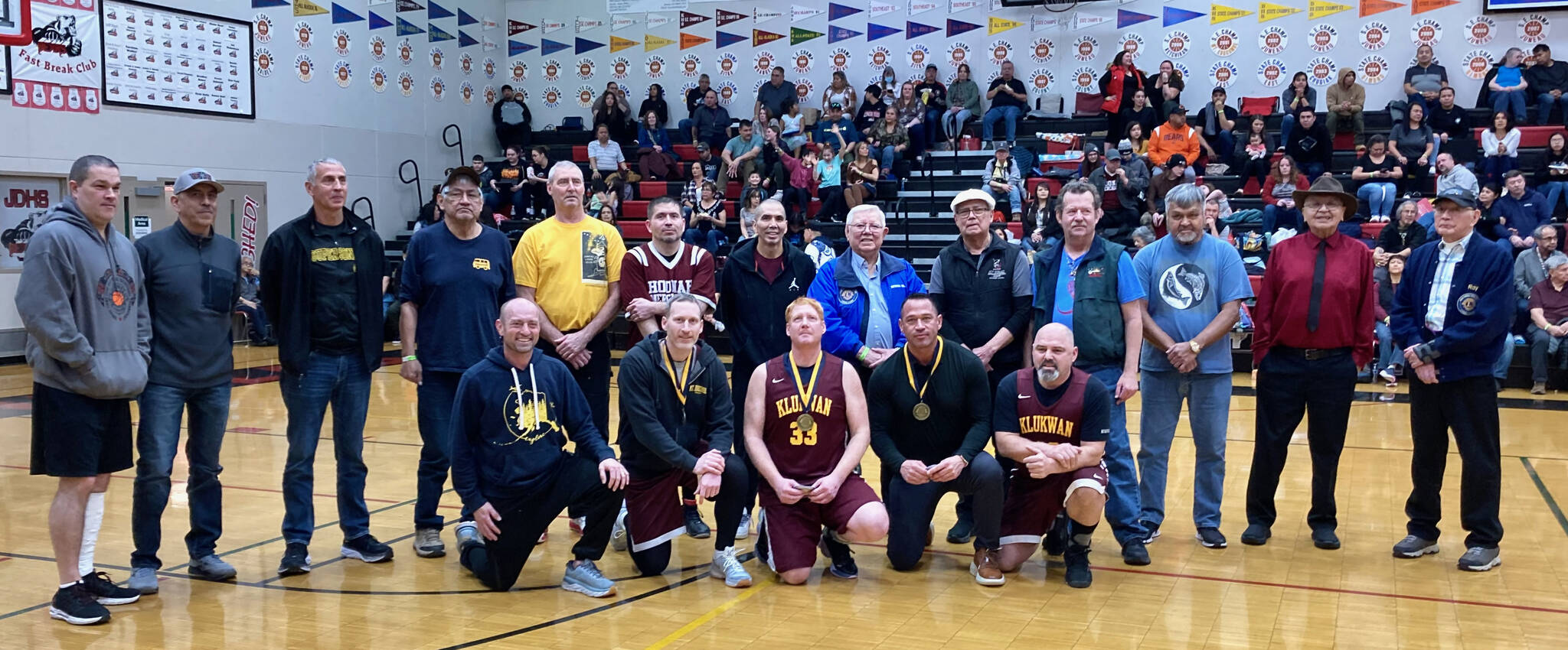 Attending members of the Gold Medal Hall of Fame pose for a photo on Friday, March 24, at the Juneau Lions Club 74th Gold Medal Basketball Tournament at the Juneau-Douglas High School: Yadaa.at Kalé gymnasium. (Klas Stolpe/For the Juneau Empire)