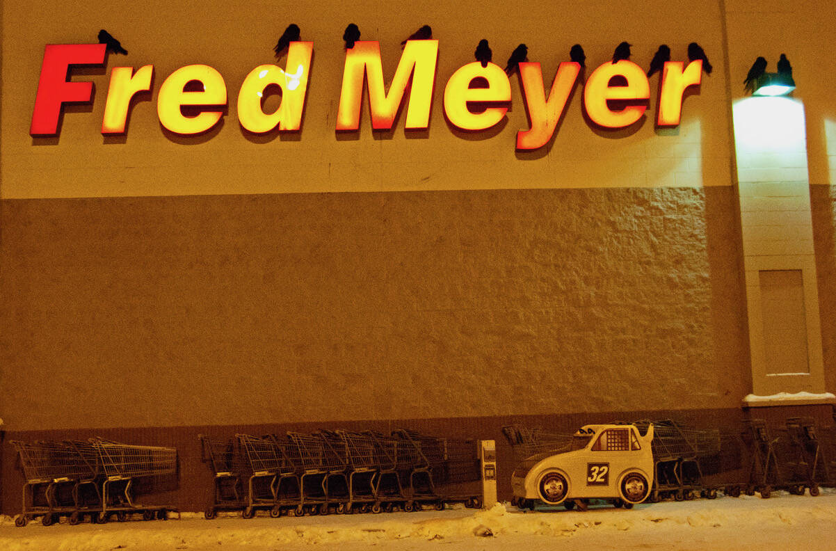 Ravens roost for the night on the letters of a grocery store in Fairbanks. (Courtesy Photo / Douglas Yates)