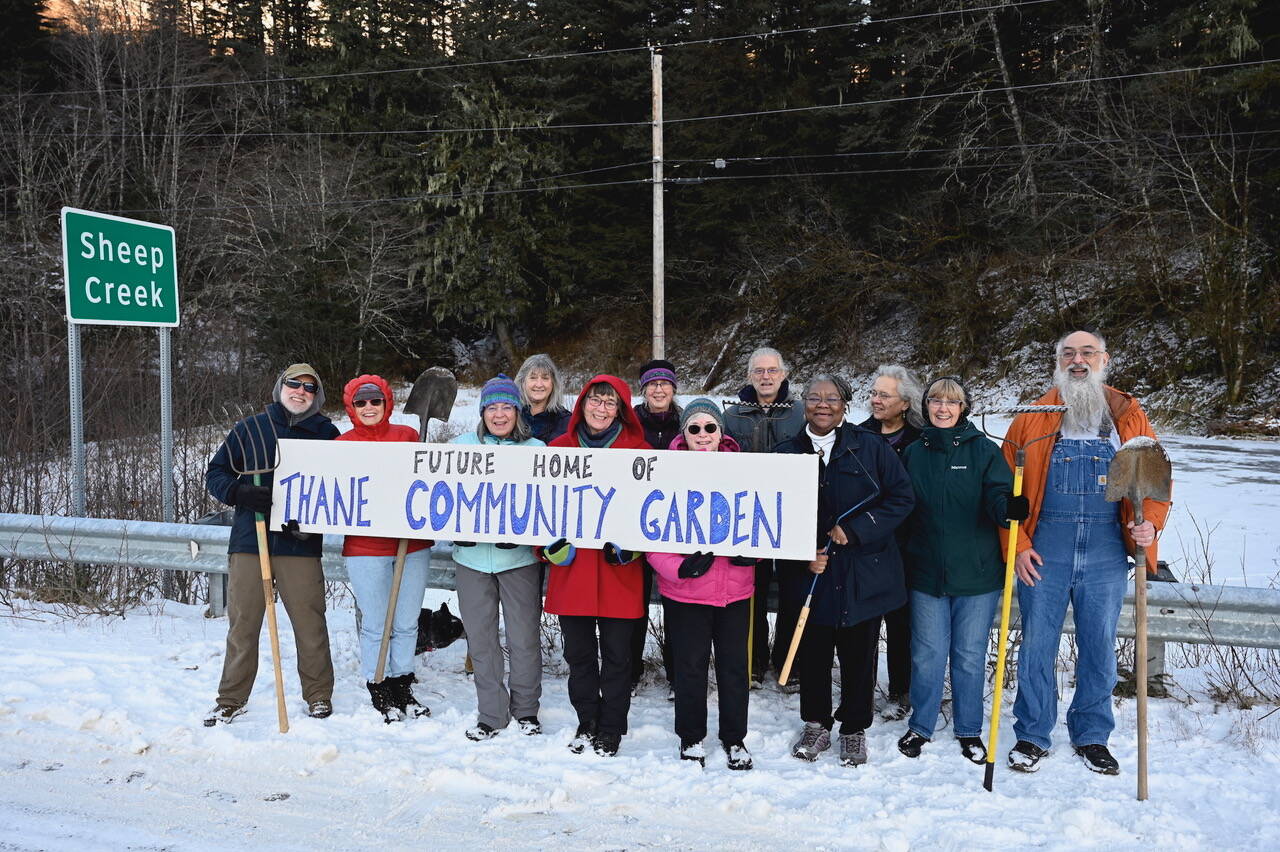 Members of the Thane Community Garden hold a sign and pose for a group photo at the location of where the new communal garden is being constructed just outside of downtown Juneau over the Sheep Creek bridge. (Courtesy Photo / Judy Sherburne)