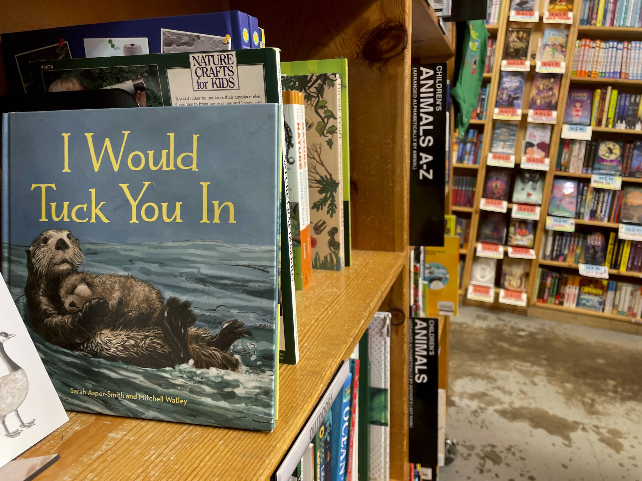 The children’s book “I Would Tuck You In,” illustrated by Mitchell Thomas Watley, is shown at a bookstore in Portland, Ore. in this April 5, 2023 photo. Publisher Sasquatch books, owned by Penguin Random House, said Wednesday, April 5, 2023, it has ended its publishing relationship with Watley after he was arrested on allegations of leaving violent, transphobic notes in stores around Juneau, Alaska. Watley told police he was motivated by fear following a deadly school shooting in Nashville that sparked online backlash about the shooter’s gender identity, court records show. (AP Photo/Claire Rush)