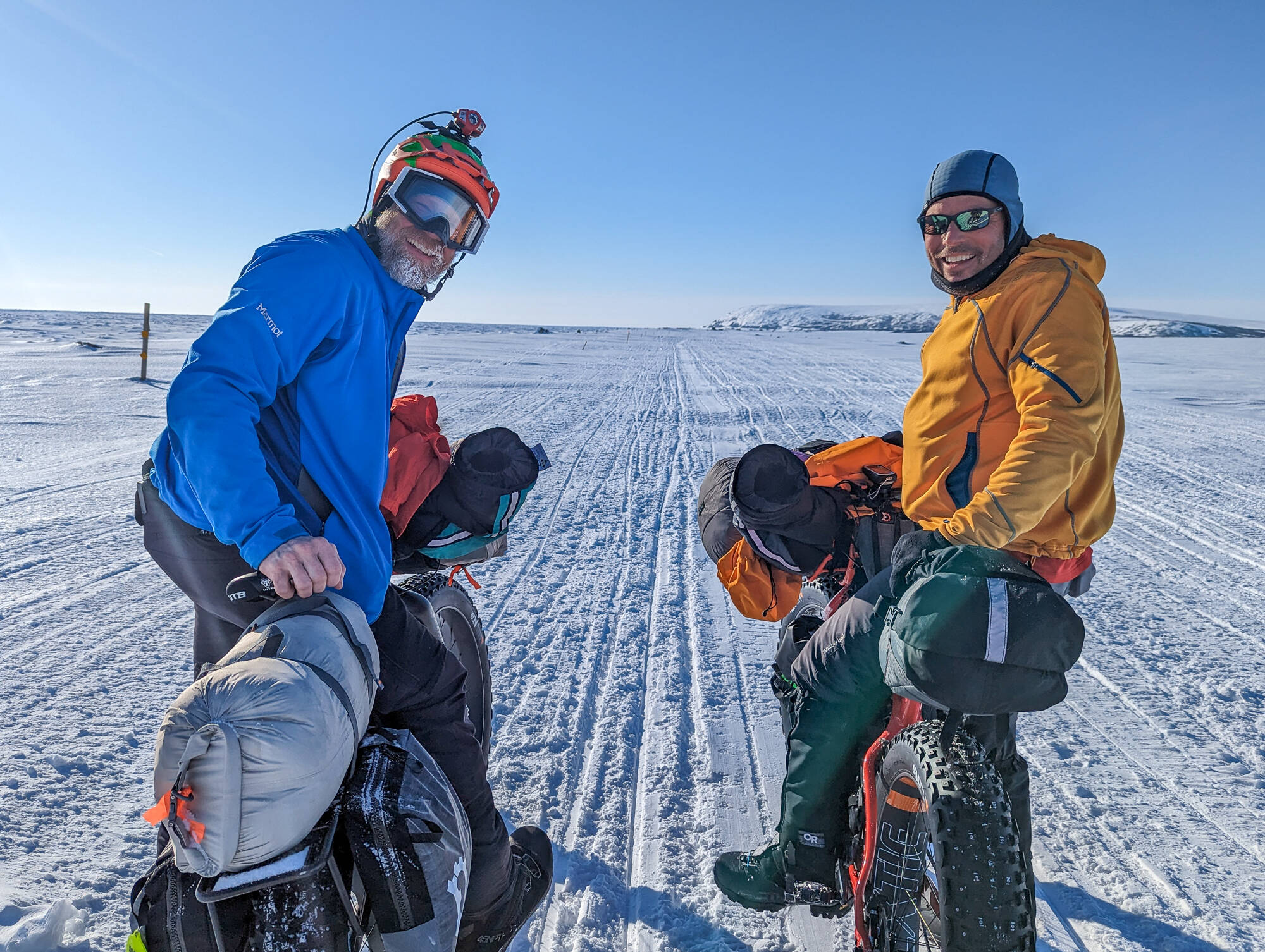Jamie Hollingsworth, left, and Bill Fleming pause with Cape Nome in the distance, within 10 miles of the finish of their 1,000-mile ride on the Iditarod Trail. (Courtesy Photo / Jay Cable)